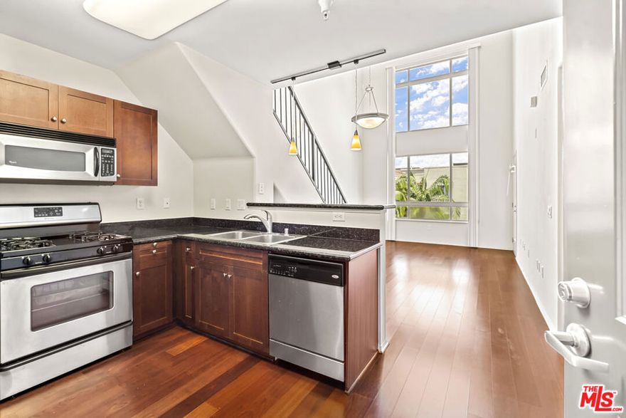 Highly sought-after top-floor residence with soaring 17-foot ceilings features 1-bedroom + loft layout and an open-concept living space with dramatic double-height windows that fill the home with natural light. The modern kitchen showcases granite countertops, rich wood cabinetry, stainless steel appliances, and a breakfast bar overlooking the spacious living and dining areas with hardwood floors throughout. The main level includes a well-proportioned bedroom with a walk-in closet, a large bathroom with a soaking tub, and side-by-side laundry. Upstairs, an airy loft offers the perfect flex space for a home office, gym, or media lounge. A private balcony completes this bright and inviting home. SAVOY residents enjoy resort-style amenities including landscaped courtyards, pool, spa, fitness center, business center, Sports Cafe clubhouse, BBQ grills, screening room, library, conference room, rooftop deck with skyline views, guest parking, and a 24-hour attended lobby. Ideally located in the heart of Little Tokyo and the Arts District, this vibrant DTLA neighborhood is surrounded by eclectic dining, art, and culture making Savoy one of the most exciting addresses to call home. ***2 Deeded Parking Spaces Included!***