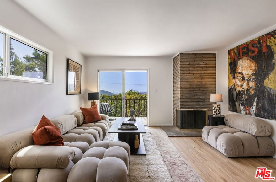 Located at the top of Mount Angelus, one of Highland Park's most coveted enclaves, this captivating c1957 Mid-Century modern home offers superb original details, endless natural sunlight, spectacular downtown skyline views, and total privacy; ensconced among tall trees on a street to street lot and feels like you have no neighbors. Enter the property from the end of the cul-de-sac at the peak of the hill on Wayland St, where there is a 2 car garage and two entrances at street level. (La Follette Drive is below the property.) Front walkway leads to main entrance and large living room with stunning character fireplace and hearth, original hardwood floors, ample dining area and spacious walk-out balcony with panoramic 180 views of greenery, architecture, and the hills-- capped by the downtown LA skyscape. Kitchen with separate entrance offers new cork floors, new appliances and cool vintage cabinetry. Featuring hardwood floors and large windows framing breathtaking views, the primary suite is spacious and private. The lower level features a large family room with abundant custom shelving from HP's Matters of Space, and two exterior entrances: one entrance to the side stairs; plus sliders opening to large deck and yard/garden--perfect for outdoor entertaining. Built-ins; ironwork, magnesite stairs, original doors and many other details give this beautiful home a true classic feel. Large laundry and utility room also opens to the outside. Explore endless local eateries like Bub and Grandmas and Joy; and walk to rec center, music venues and theaters. Feel space, privacy and nature with the city at your fingertips: centrally located to downtown, Pasadena and Glendale.