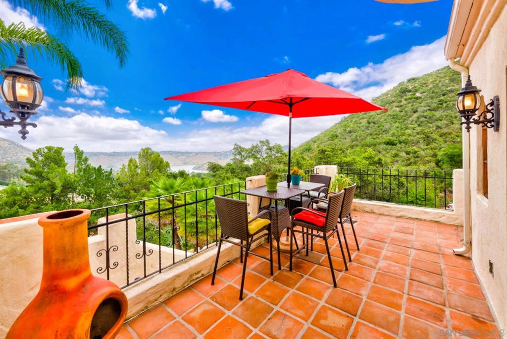 Perched atop one of the highest peaks in San Diego County, this stunning Mediterranean-style rental offers panoramic views of Lake Hodges, seasonal waterfalls, and mountains in every direction. Located in the Lake Hodges community and bordering exclusive Upper Cielo of Rancho Santa Fe, this custom home blends serenity with access to adventure. Set on a private 1.09-acre lot beside 100+ acres of open space, the three-level home embraces its natural surroundings with large archways, wraparound verandas, and expansive windows that flood the space with light. Each bedroom is a private retreat with its own en-suite bath, and a flexible fourth room serves as an office or guest space. The gourmet kitchen opens to a generous terrace for seamless indoor-outdoor living. Custom woodwork, handcrafted tile, and warm finishes add character throughout. Enjoy nearby hiking, biking, fishing, or simply unwind in the peaceful setting. Just 12 miles from the coast, this elevated home offers a rare opportunity to rent in one of North County’s most scenic locations. Experience life above the clouds—where every sunrise is unforgettable.