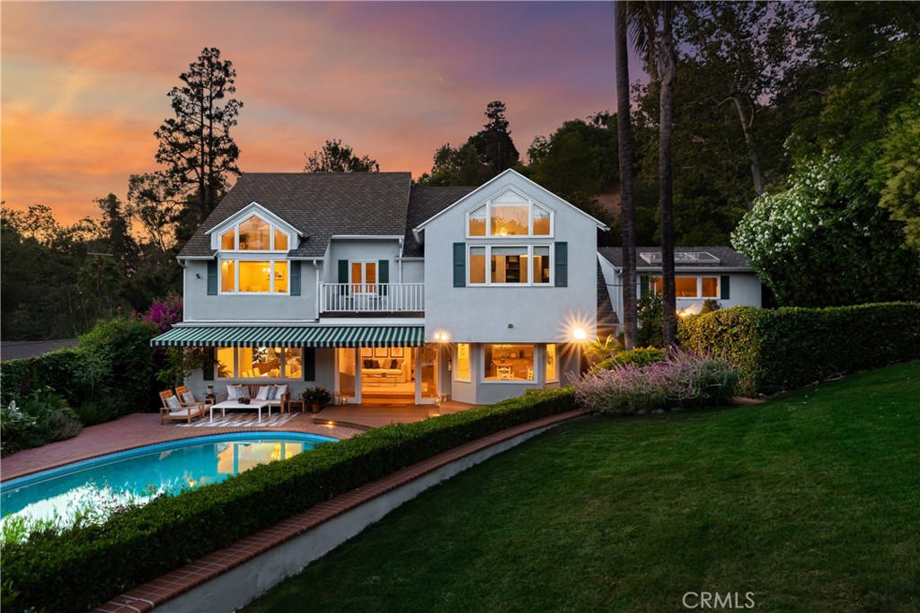Tucked away in the hills of Studio City at the end of a secluded cul-de-sac, this gated celebrity compound sits on a sprawling 13,000+ sq ft lot that offers complete privacy and breathtaking views. Featured in numerous publications, this enchanting 1940s Cape Cod estate – complete with a separate guest house – has been beautifully updated throughout, thoughtfully blending timeless charm with modern amenities. The bright and airy main level welcomes you with a spacious open-concept formal living and dining room that flows seamlessly into an inviting family room, here double French doors open for indoor-outdoor living and entertaining. A culinary enthusiast's dream, the designer chef's kitchen is equipped with top-of-the-line Viking appliances, granite countertops, and a sun-drenched breakfast nook. Upstairs, you'll find four generously sized bedrooms, including two with vaulted ceilings and oversized windows that perfectly frame the picturesque vistas. One of the bedrooms boasts a loft space, while the other has access to a private balcony. The expansive primary suite serves as a private sanctuary, featuring stunning views, a cozy fireplace, dual walk-in closets with custom built-ins, and a spa-inspired ensuite bathroom, complete with a clawfoot soaking tub that's bathed in natural light from two skylights above, a rainfall shower, and double vanity. Designed for privacy, the serene backyard is enveloped by lush mature landscaping and boasts no visible neighbors or overhead utility wires. This park-like retreat is highlighted by a sparkling PebbleTec pool, built-in spa, and outdoor speakers. The guest house, with its own private entrance from the street, offers a kitchenette and full bathroom – a perfect setup for extended family, guests or rental income opportunities. Additional amenities include a large office with a private entrance, a laundry room, security system, gated driveway, and two-car garage with a Tesla supercharger. Ideally located south of the Boulevard in the exclusive Fryman Canyon Estates (a fire-wise community with access to deep discounts for fire insurance), this exceptional property lies within the coveted Carpenter School District and is just moments away from trendy restaurants, boutique shops, Fryman Canyon hiking trails and so much more.