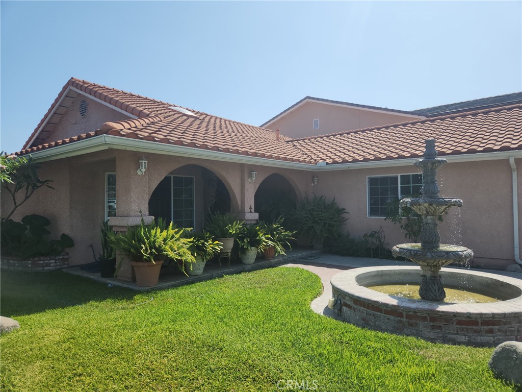 First time on the market - beautiful home! Spacious, single story 3-bedroom, 2-bath home and 2-car garage. This corner lot home offers a nice-size wrought iron and block fenced front yard with a fabulous water fountain. As you walk through the front double doors and into a nice formal living room, you'll find the open foyer leading to the kitchen-dining room. The family room features a cozy fireplace. The primary room with its ensuite bath. Two other spacious bedrooms complete this amazing home. The backyard has a covered patio, perfect for entertaining, it's spacious with lots fruit trees and a secured block wall. The home is conveniently located for easy commute to work, amusement parks, dining, shopping or the beach. Preview it today!