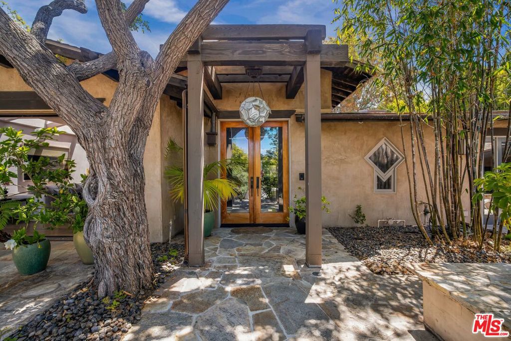 THE ULTIMATE BIRD STREETS PRIVATE OASIS. Featured in Architectural Digest and Elle Decor, this quintessential California residence offers unmatched indoor-outdoor living in one of the city's most coveted locations. Each bedroom opens to its own private outdoor space or the secluded backyard, which features mature lush landscaping, a pool/spa, a fully equipped outdoor kitchen, dining area, and fireplace. The three-bedroom home is outfitted with security cameras throughout and includes an automated Crestron system. A separate guest unit with full bath sits above the garage, completing this thoughtfully designed property. Gated entry plus additional parking in front. A rare paradise in the heart of the Bird Streets.