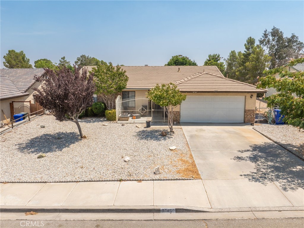 Welcome to 13745 Bel Air Drive, a charming single-story home located in the heart of Victorville, offering beautiful views of the scenic Green Tree Golf Course. This well-maintained property features three bedrooms, two bathrooms, and 1,404 square feet of comfortable living space, perfectly situated in a peaceful, established neighborhood with no HOA.
From the moment you arrive, you’ll appreciate the inviting curb appeal with low-maintenance, drought-tolerant landscaping, mature trees, and a gated front patio that creates a private and welcoming entry. Inside, the living room offers a cozy and functional layout with plush carpeting, a classic stone fireplace, ceiling fan, and plenty of natural light. A sliding glass door leads to the enclosed sunroom, providing a relaxing space to unwind while enjoying views of the backyard and lush greenery beyond.
The kitchen features oak cabinetry, tile countertops, and ample prep space, along with a breakfast bar that opens to the dining area. The dining nook is surrounded by windows, making it the perfect spot to enjoy meals in a bright, cheerful setting.
The primary suite includes a mirrored closet, ceiling fan, and a private bathroom with a walk-in shower. Two additional bedrooms offer flexibility for guests, a home office, or growing families. The second full bathroom includes a tub and shower combo and is conveniently located near the secondary bedrooms.
The backyard offers a serene and private space with a concrete patio and mature landscaping, all while enjoying peaceful views of the Green Tree Golf Course just beyond the fence. It’s the perfect place to relax, entertain, or simply take in the calming surroundings.
Additional features include central heating and air, ceiling fans throughout, and a two-car garage providing ample parking and storage. With a practical single-story layout and a picturesque setting, this home is ready for you to make it your own.
Conveniently located near shopping, restaurants, schools, and with quick access to the 15 freeway, this home offers comfort, value, and a desirable lifestyle. Don’t miss your opportunity to make 13745 Bel Air Drive your new home—schedule your private showing today!