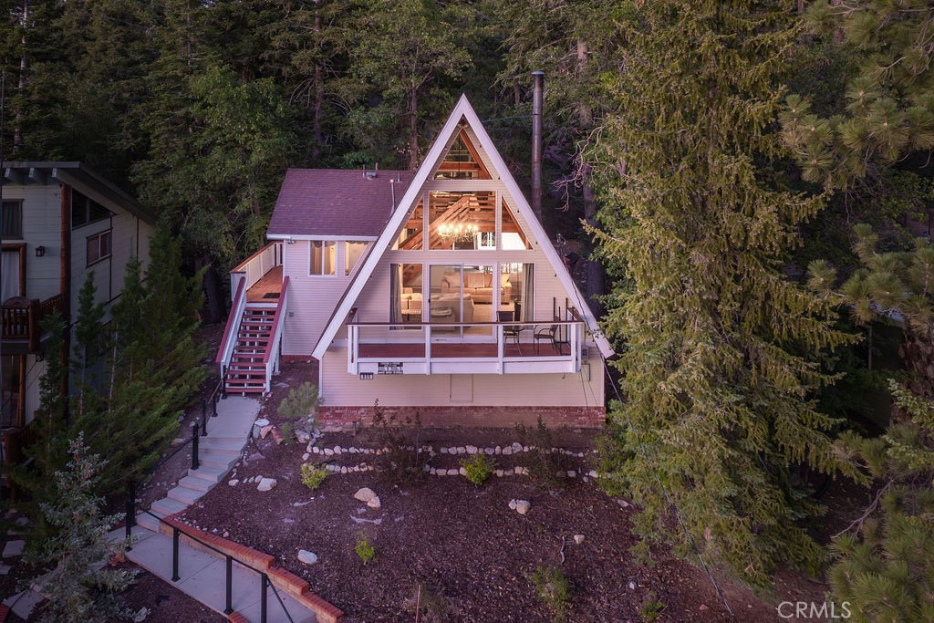 Tucked beneath a canopy of whispering pines, this picture-perfect A-frame is the ultimate mountain getaway! An enchanting retreat designed for cozy weekends, romantic escapes, and unforgettable memories. Located in the highly desirable Moonridge neighborhood of Big Bear Lake, this stylish mountain home is just around the corner from Bear Mountain Ski Resort, Big Bear Golf Course, the Alpine Zoo, scenic hiking trails, incredible mountain biking, Moonridge Coffee and Dank Donuts. Inside, you’ll be captivated by the dramatic architecture, soaring vaulted ceilings with exposed wood beams, iconic A-frame windows that flood the space with natural light, and a warm, inviting layout perfect for relaxing or entertaining. The spacious living room features a freestanding wood-burning stove, balcony lounging, and incredible views from every angle. Whether you're curled up by the fire after a day on the slopes or enjoying a quiet morning coffee, the cabin offers a true alpine experience. The open kitchen and dining area make hosting effortless, while the upstairs loft serves as a romantic primary suite; airy, tranquil, and surrounded by trees. And having two bathrooms is so convenient! With 1,066 square feet of living space, this turnkey cabin lives much larger than expected. Step outside to your private backyard deck with built-in seating and a gas fire pit, perfect for stargazing. An upslope lot and oversized driveway offer parking for 3 vehicles, an uncommon bonus in this sought-after area. Whether you’re looking for a vacation home, short-term rental investment property, or even a dreamy full-time residence, this gorgeous cabin is only 2.5 hours approximately from Los Angeles, Orange County, and San Diego, making weekend getaways to the mountains easy! Don’t miss your chance to own this iconic Big Bear A-frame in one of the most beloved neighborhoods in the mountains—schedule your showing today!