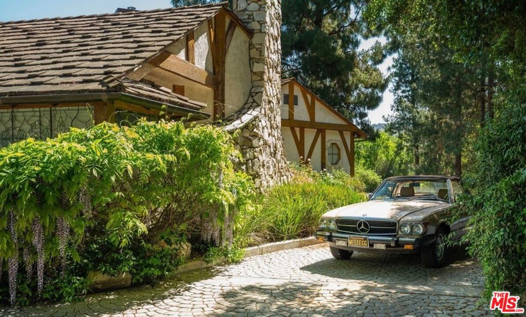 Welcome to this famed private estate, a secluded, one-of-a-kind gated 2-acre property tucked away at the end of a quiet street in Fryman Canyon. A long, private driveway leads to the grand ~7,000sqft Robert Byrd-designed Tudor main house, boasting 5 bedrooms, 6 bathrooms, and stunning architectural details like dramatic beamed ceilings, stone fireplaces, and hardwood floors throughout the main level. The oversized primary suite offers expansive walk-in closets and bright views of the valley. Outside, your backyard oasis awaits, featuring a pool and spa framed by lush greenery. The property also includes a motor court leading to a Championship Tennis court and an impressive 25+ car garage. A detached guest house, offering an additional ~2,000sqft of flexible living and entertainment space to make your own. Towering mature trees envelop the entire 2-acre estate, transporting you to your dream oasis. An additional parcel at 12001 Briarvale Lane, adding another 19,012 sq ft, is included.