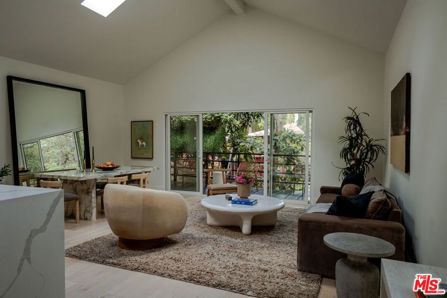 Tucked within a serene, tree-lined enclave, this fully reimagined 3-bedroom, 3-bath retreat perfectly balances design, privacy, and nature. Behind a gated driveway, the home feels worlds away while remaining moments from both the city and the valley. Soaring vaulted ceilings, wide-plank hardwood floors, and skylights create a luminous open layout that flows effortlessly from the living and dining areas to an expansive wraparound deck, ideal for entertaining or unwinding beneath the trees. The chef's kitchen showcases bespoke cabinetry, top-tier appliances, and a charming breakfast nook overlooking lush surroundings. The light-filled primary suite features a spa-inspired bath with dual sinks, a walk-in closet, and direct access to the deck. Downstairs, a spacious bonus suite with a full bath and closet offers versatility for a guest suite, home office, or creative studio. Surrounded by mature landscaping and multiple outdoor living spaces, this turnkey property delivers a rare sense of calm and connection to nature, just moments from the acclaimed Wonderland School and the best of city living.