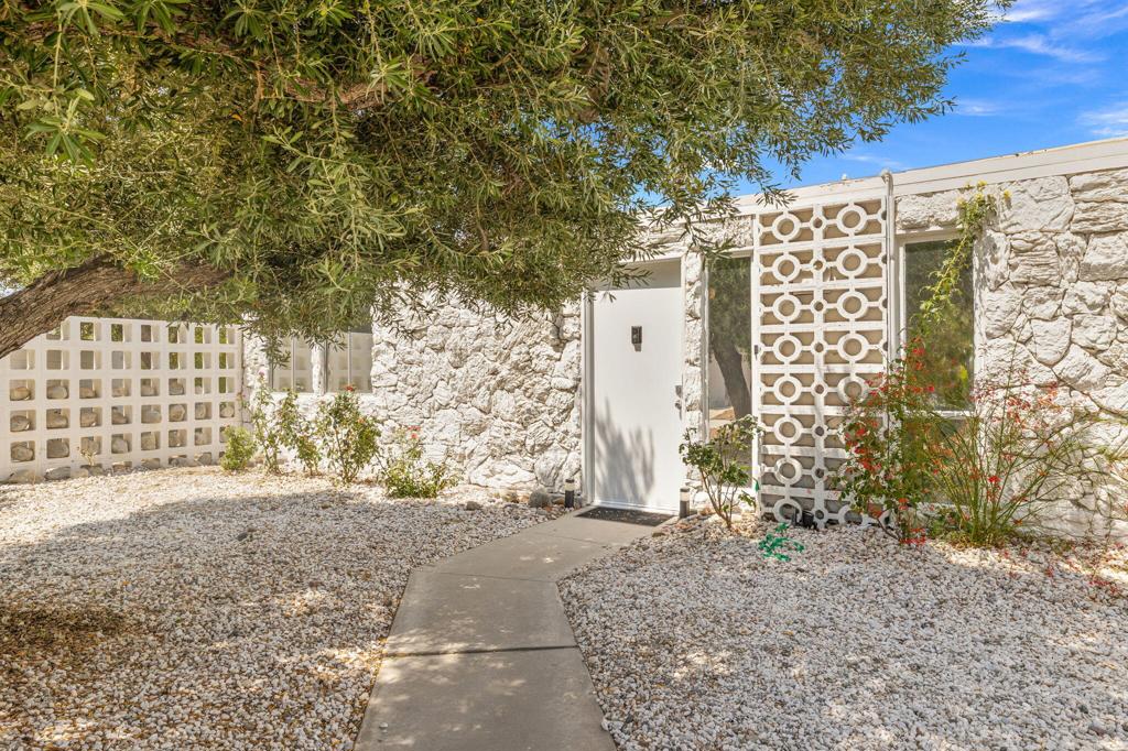 Tucked away on a private cul-de-sac in Racquet Club Estates, this iconic midcentury home was designed by architects Dan Palmer and William Krisel and built by the Alexander Construction Company. Hand-selected by Steve McQueen as his personal desert retreat, the property sits on one of the neighborhood's premier lots, offering dramatic San Jacinto views and exceptional privacy.McQueen's custom-designed, south-facing pool is ideal for swimming laps or diving from the board. Two conversation areas are integrated into the expansive wrap-around yard, surrounded by mature trees and a citrus grove planted by McQueen himself, perfect for entertaining or quiet relaxation.The white stone facade opens into a sleek, all-white interior where European minimalism meets classic post-and-beam design. Original features include perforated ceiling tiles, a floating inset fireplace, and walls of glass that connect indoor spaces to the outdoors. The open kitchen is outfitted with marble-topped Pierre Cardin cabinetry with matching bar and a Wolf range.This is the very home where Life magazine photographed McQueen in 1963, lounging poolside and slow dancing in the living room. A rare chance to own a true piece of Palm Springs history -- boldly stylish and effortlessly timeless. All key systems have been recently updated.