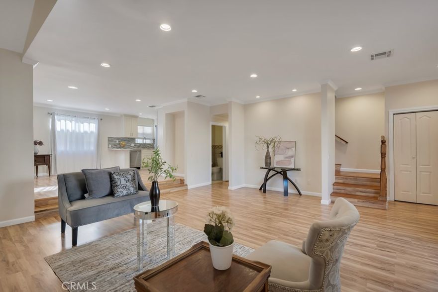 Discover this beautifully reimagined 3 bed + 3 bath tri-level corner townhome, perfectly situated in the heart of North Hills. This light-filled residence blends modern style with everyday comfort, offering an inviting layout ideal for both relaxing and entertaining. Step into a warm, airy living room featuring a striking marble-accented fireplace and direct access to a private patio overlooking the peaceful courtyard. From there, the split-level design guides you up to a spacious dining area that flows effortlessly into a contemporary kitchen. The wrap-around kitchen impresses with Quartz countertops, custom cabinetry, full tile backsplash, waterproofed laminate floors, recessed lighting, and sleek Samsung stainless steel appliances. The second level hosts an expansive primary suite designed for luxury living, complete with laminate flooring, crown molding, dimmable LED lighting, a generous walk-in closet, and a spa-inspired bathroom with dual Quartz vanities and a stunning glass-enclosed shower. Two additional bedrooms, also located on the second level, offer great natural light, mirrored closets, and the same refined finishes. The hallway bath features a modern vanity, framed mirror, and a jetted Jacuzzi tub for unwinding. Convenience continues with a large side-by-side laundry area, extra storage, and direct access to the attached 2-car garage. Additional upgrades include laminate floors throughout most of the home, porcelain tile accents, solid wood staircases, custom railings, and LED lighting in nearly every room. The gated community provides low HOA dues that cover water and trash, plus added perks such as security patrol, guest parking, grassy common areas, a serene courtyard, and a sparkling pool, perfect for enjoying sunny North Hills afternoons. A true gem in North Hills, offering style, comfort, and incredible value all in one.