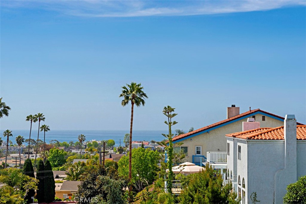 Do not miss Summer in Dana Point! Walk or bike to town, Doheny Beach or Dana Point Harbor! This beautiful Cape Cod style home with casita is located in the heart of Dana Point's Lantern Village and offers ocean views and coastal living at its finest. The house has over 3600 sq ft of living space and features 4 bedrooms and 3.5 bathrooms. The spacious primary suite has vaulted ceilings, large warm fireplace, and bathroom suite with a jacuzzi tub and walk-in shower. The upper level also has two oversized bedrooms with ample closet space and off the primary bedroom - an expansive ocean view deck. The open and well-lit kitchen is perfect for entertaining, with an oversized walk-in pantry, center island, and endless counter space. The kitchen also connects to the family eating area and another large ocean view deck, extending the outdoor living space. The separate main level fourth bedroom is over 700 sq ft and can be used as guest quarters, a personal business, or private office, art studio, media room, or granny flat. The beautifully re-landscaped yard features a soothing Jacuzzi hot tub, providing a private retreat with custom lit privacy fence. The home is located on one of the nicest single loaded streets in Lantern Village, within walking distance to Dana Point's beautiful beaches, harbor, restaurants, and shops. The house also has double-paned windows, granite countertops, two fireplaces, and ample storage space and closets. With brilliant freshly updated elements thought and detail invested into every space, this home represents elegant coastal living.