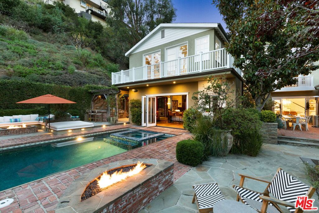 Step through the gates to explore this magical secluded compound in the Hollywood Hills, just above the twinkling lights of the Sunset Strip. This seductive home, which is the perfect blend of 1936 design and 21th century functionality, sits on a sprawling near half-acre of lush manicured grounds. The abundance of trees on the property creates a sense of solitude and privacy. Home highlights are a sparkling pool & spa, multiple fire pits, an outdoor kitchen, a screening room with a full bar and plenty of space for memorable entertaining. The guest house features a Savant screening room and a full size bar, and upstairs two generous rooms with a shared closet and full bathroom, that can be used as bedrooms, a workout studio or as an office with views of the city skyline. The main house, which is flooded with sunlight, has an enviable cooks kitchen with a large butcher block island, a breakfast nook, Viking appliances, and a wine fridge. Vaulted ceiling with stunning crown molding and hardwood floors flow through the home. The spacious dining area easily accommodates a table for 10+ guests and connects thru a grand arched doorway to a splendid living room alive with 1930's character, with a fireplace that serves as the focal point. The top floor primary mirrors the lower floors vaulted ceiling, has a grand walk-in closet and a balcony with an additional cityscape vista. The adjoining bath has a glamorous marble shower, a soaking tub, and dual vanity sink. Adding to the endless charm of this property, perched on the edge of the lot is a completely renovated cottage / creative space. The carport is equipped with an EV charger and the motor court allows for parking for additional cars. This unparalleled, exceptional property is gated and secure. For the most cultivated buyer, this unique home is "sui generis". Total square footage is inclusive of the screening room / bar / guest house. Available furnished at an additional charge.
