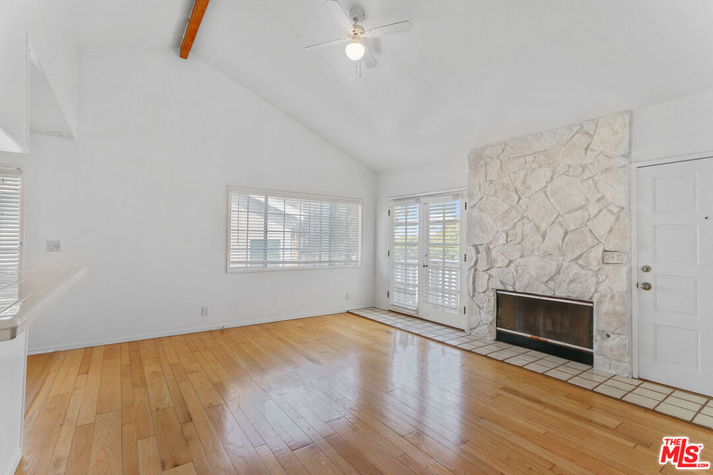 Charming Hilltop Apartment in Sunset Park -- Perched on a tranquil hilltop street with refreshing ocean breezes, this lovely second-level apartment offers the perfect blend of privacy and charm. Located in a detached, freestanding building with no shared walls, the home is accessed via a private entrance. Step into a spacious living room featuring soaring ceilings, a decorative fireplace, and French doors that open to a sunlit balcony deck. Hardwood floors flow throughout, complemented by the kitchen's new luxury vinyl plank flooring. Besides brand new kitchen cabinets, the light and airy apartment offers two bedrooms, a full bath, and a half bath. Fireplace is decorative. The primary bedroom boasts vaulted ceilings and generous closet space. Additional highlights include: A landscaped yard with seating and barbecue, Central heating, Private garage, Private washer and dryer, Resident and guest-permitted street parking, Smoke-free environment (per Santa Monica Ordinance), Water and gardener. -- A serene, character-rich retreat in the heart of sought-after Sunset Park.