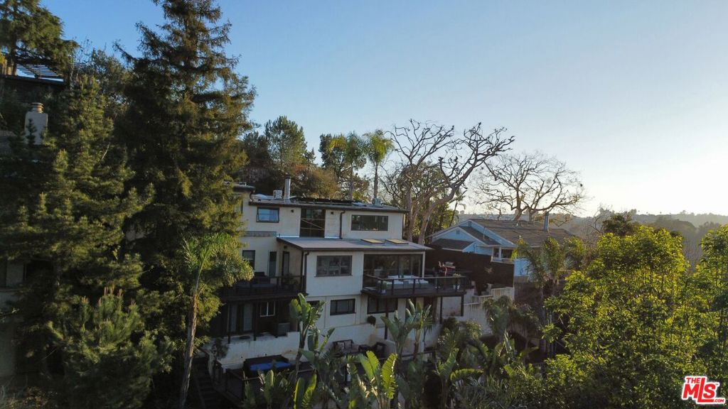 Iconic modern masterpiece offering luxury, thoughtful design, and breathtaking views. FULLY FURNISHED and move-in ready with cookware, dishes, and linens, this pristine 3-bedroom, 3-bath home also features a large family den with kitchenette as well as a converted garage perfect as a studio, office, maid's quarters or 4th bedroom. Seamless indoor-outdoor living connects wide glass doors to the expansive 2,000 sq. ft. deck with outdoor seating and a fully equipped outdoor kitchen. The lush terrace, shaded by mature trees, includes a private dry sauna and opens to a large flat yard. Light and bright with clean lines throughout, the home boasts two fireplaces, Brazilian Cherry and Oak hardwood floors, and a master suite with a full wall of built-in Walnut closets. The Bontempi kitchen showcases top-of-the-line appliances, including a Sub-Zero fridge, Miele cooktop, and Thermador microwave/oven, complemented by Carrara marble countertops and Wenge wood cabinets. Additional amenities include flat-screen TVs, a washer/dryer, and a purified filtered water system. Conveniently located just minutes from Beverly Hills and Studio City. Make this dream home yours today!