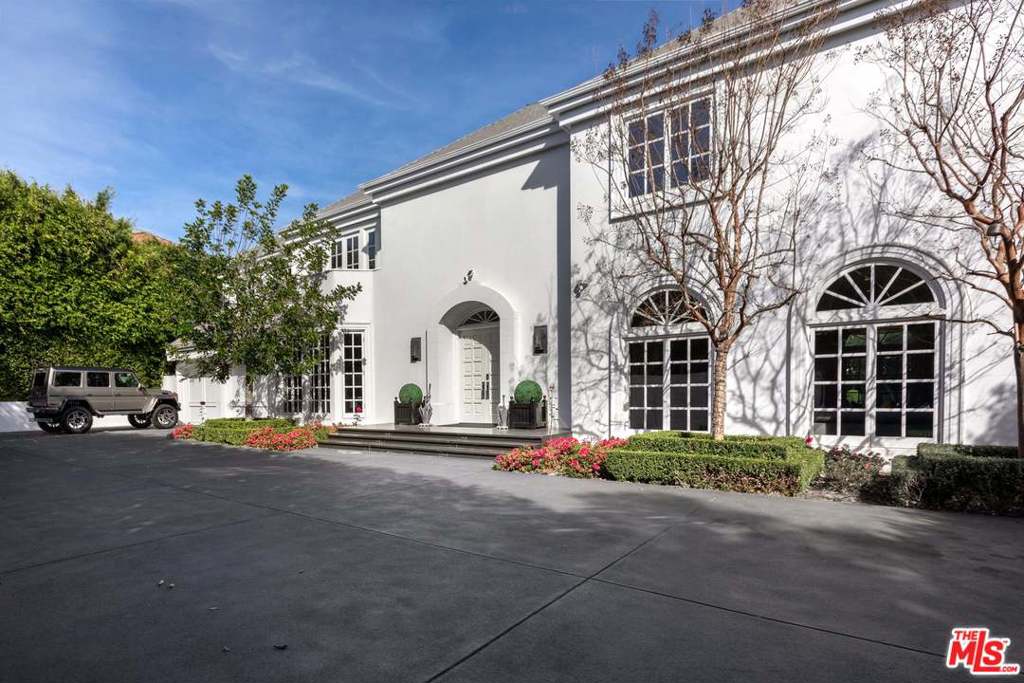 Enclosed by gates & lush landscaping sits this grand French estate, situated on an over half-acre lot in the highly sought-after Beverly Hills Flats. Upon entering the formal two-story foyer with French limestone flooring & winding staircase, you'll bask in abundant natural light & opulence. High ceilings & an expansive open floor plan offer the perfect spaces for entertaining & intimate gatherings. The formal living room is encased by French doors that open to the beautiful grounds, which boast an exceptional resort-style setting with spacious patio spaces, expansive lawns, plus a pool/spa. Second level has 5 bedrooms with en-suite baths, a sophisticated master suite complete with fireplace, dual baths, walk-in closets, sitting room, & sauna. With the latest technology by Crestron & Nest, maid's room/office, library, 3 car garage & motor court, this property has everything you could want & all a stones' throw away from the best shopping and restaurants Beverly Hills has to offer.