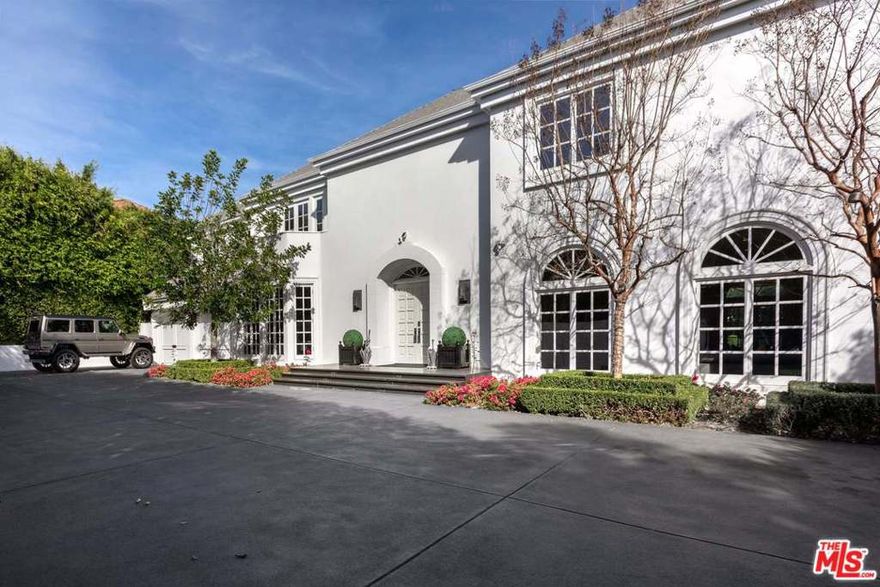 Enclosed by gates & lush landscaping sits this grand French estate, situated on an over half-acre lot in the highly sought-after Beverly Hills Flats. Upon entering the formal two-story foyer with French limestone flooring & winding staircase, you'll bask in abundant natural light & opulence. High ceilings & an expansive open floor plan offer the perfect spaces for entertaining & intimate gatherings. The formal living room is encased by French doors that open to the beautiful grounds, which boast an exceptional resort-style setting with spacious patio spaces, expansive lawns, plus a pool/spa. Second level has 5 bedrooms with en-suite baths, a sophisticated master suite complete with fireplace, dual baths, walk-in closets, sitting room, & sauna. With the latest technology by Crestron & Nest, maid's room/office, library, 3 car garage & motor court, this property has everything you could want & all a stones' throw away from the best shopping and restaurants Beverly Hills has to offer.