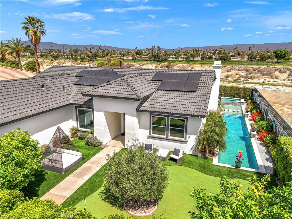Welcome to one of Palm Desert’s most refined and private retreats, nestled on an expansive 10,454 sq. ft. lot in a coveted neighborhood setting. This newly reimagined home has been thoughtfully upgraded with luxury finishes and modern amenities, offering a seamless blend of indoor-outdoor living and resort-style sophistication.
At the heart of the home is a designer kitchen outfitted with premium Viking appliances—elegant yet functional, ideal for both relaxed mornings and elevated entertaining. Natural light pours through brand-new windows and sliding glass doors, while newly remodeled showers and a brand-new A/C unit enhance everyday comfort.
Outside, a private oasis awaits: a 52-foot lap pool, a stunning 40’x25’ smart-controlled designer pool, and a 10-person spa anchor the showstopping outdoor experience. A putting green, citrus trees, and lush hedging frame the grounds, while multiple dining and lounge areas—complete with a pizza oven, bar seating, and two LED TVs—set the tone for unforgettable gatherings. A striking 70-foot mural by celebrated artist Steven Van Art adds a one-of-a-kind Coachella-inspired backdrop.
Previously a successful high-end vacation rental favored by celebrities, athletes, and musicians, this estate offers an extraordinary opportunity—whether as a full-time residence, seasonal escape, or investment.