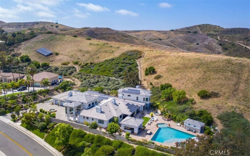 Sophisticated Coastal Estate on 2.65 Acres | 8-Car Garage | Vineyard | Movie Theater
Nestled on an expansive and premier over-sized lot, this extraordinary custom estate offers unmatched privacy, luxury, and lifestyle across 2.65 acres of refined coastal living. Beyond the double iron gates, a grand circular motor court with a central fountain welcomes you—complete with ample guest parking and space for a recreational vehicle. Car enthusiasts will appreciate the 8-car (2,000 sqft) garage with vaulted ceilings, tons of built-in storage, and its own bathroom!
Covered entryway with glass panel doors leads you into 7,200 sqft of downstairs living space which includes a light-filled, two-story decadently-furnished living room, powder room, wine room, home theater fit for a movie mogul, gourmet kitchen with quartz countertops and hidden tv that descends from the ceiling, family room, main-floor master suite (on the East wing).
The estate features dual master suites, both upstairs and downstairs, situated at opposite ends of the home for ultimate privacy. The upstairs west wing master suite spans over 1,500 sq ft and includes a secret 350 sq ft custom closet—a true showstopper for anyone who needs an ultimate closet like no other. The huge main-level master and extra-large walk-in closet, located in the east wing, provides ideal single-level living or guest accommodations. Three additional large bedrooms offer space and comfort for everyone.
Outdoors, enjoy a resort-style backyard with a diamond-shaped pool and spa, a covered outdoor kitchen and bar, and built-in surround sound for seamless indoor/outdoor entertaining.
Nestled among flourishing citrus and stone fruit orchards, this exceptional property also features thriving avocado trees, creating a lush and bountiful landscape. A true highlight is the private vineyard, which yielded an impressive 1,000 bottles of wine last year—bringing the charm, flavor, and romance of wine country right to your own backyard.
This is more than a home—it’s a lifestyle. Bring your suitcase and move right in to this fully furnished masterpiece. This property must be seen to be fully appreciated.