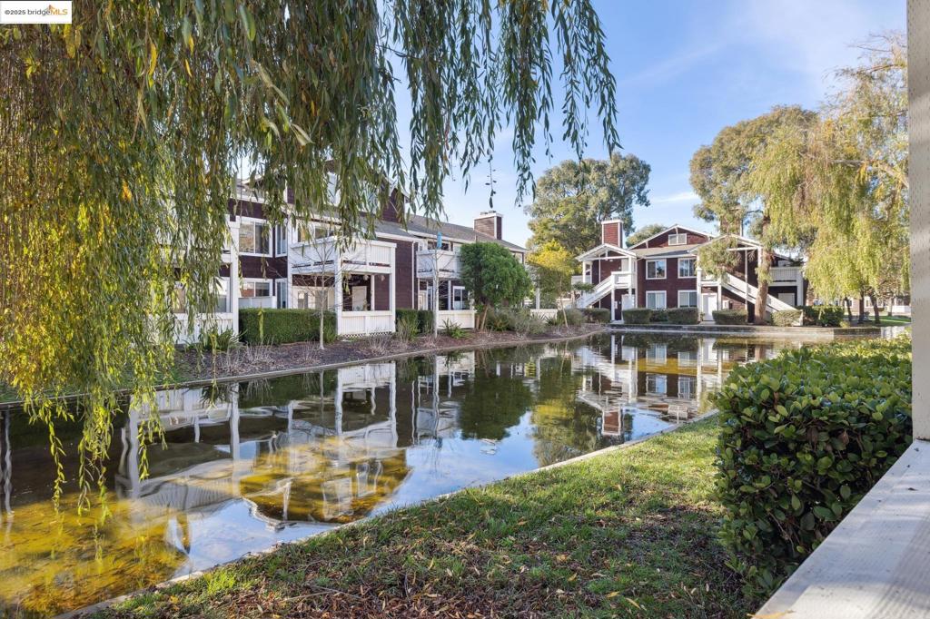 Discover the charm of California Coastal Resort Living at 89 Bayside Court, a 1-bedroom, 1-bath condo in the heart of Point Richmond. This bright and airy lower-floor unit features an open floor plan with hardwood floors and a romantic wood-burning fireplace. While the kitchen and bath maintain their classic appeal, the unit's well-maintained interior is in great condition and ready for your bespoke updates. Enjoy direct lagoon views from your private patio, which also includes additional storage. With no stairs, this unit provides easy accessibility. Situated in the gated Marina Bay community, you'll have access to top-notch amenities, including a state-of-the-art fitness center, two heated pools, hot tubs, and lighted tennis/pickleball courts. The community offers designated carport parking, electric car charging stations, a clubhouse, and a community garden. Just steps away, the scenic Bay Trail is perfect for walking, cycling, or enjoying the serene waterfront views. Commuters will appreciate the easy access to highways 580/80, BART, and the San Francisco ferry. Embrace a lifestyle of tranquility and potential in this coastal retreat.