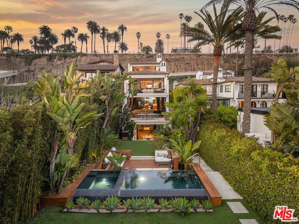 Welcome to Villa Molori, a legacy estate along the famed Palisades Beach Road in Santa Monica. Once graced by legends like Charlie Chaplin and Howard Hughes, this exclusive enclave known as the original "Billionaire's Beach"is now home to tech moguls, film executives, and captains of industry seeking the ultimate coastal retreat. Crafted by Molori Design, this world-class resort-style estate exemplifies coastal luxury. With multiple access points and proximity to first responders, experience unmatched serenity with 24-hour private security and a fully staffed fire station just yards away. From the lushly landscaped grounds and private infinity-edge pool with hot tub and cold plunge, to the open-air stainless steel kitchen by Kalamazoo and dual alfresco lounge areas, every inch of the exterior was designed for both celebration and serenity. Tropical gardens and soaring palms form a green cocoon of privacy while offering unobstructed ocean views that stretch to the horizon.Inside, soaring ceilings and wide-plank chevron oak floors lead you through a gallery of European-inspired luxury. Floor-to-ceiling glass doors open to create united indoor and outdoor spaces, blurring boundaries between architecture and nature. A grand formal living room is framed by Ebony Macassar and Thassos stone, opening to an expansive deck ideal for sunset entertaining. A statement fireplace anchors an outdoor dining area set beneath the stars, wrapped in tall bamboo for ultimate seclusion. The chef's kitchen, inspired by the famed El Bulli restaurant and designed in collaboration with culinary innovator Juan Carlos Ramos, features bespoke cabinetry and Wolf & Sub-Zero appliances. An elegant dining room seats up to 25 guests, flanked by French doors and ocean breezes. Upstairs, the showstopping primary suite is a sanctuary of light, warmth, and view. Vaulted ceilings with exposed beams and a sculptural wood fan crown a space anchored by a sleek fireplace and floor-to-ceiling doors that open to a private balcony. Enjoy watching your best films with a full screen projector and surround speakers. Herringbone floors echo the craftsmanship throughout, while a spa-worthy bath with copper double slipper tub and steam shower completes the retreat. A second primary suite mirrors the luxury, with retractable glass walls and a private terrace with rooftop jacuzzi. Every bedroom feels like a five-star hotel suite, featuring built-in coffee stations, private bars, and luxurious en-suite baths. A state-of-the-art home theater, gym, yoga/pilates studio. The villa also features a modern minimalist steam room with a unique heavy metallic porthole window. The massage room features a Murphy bed and can be turned into a 6th bedroom. A Geothermal radiant serves for the floor & pool heating speaks to the no-expense-spared ethos. Technology meets tranquility with full Control4 home automation, sound-engineered windows and doors, a private garage and generous guest parking. Surrounded by neighbors such as George Rosenthal or David Bonderman, this stretch has long attracted A-listers and visionaries. The home was untouched and not evacuated during recent wildfires testament to its prime location and enduring security. A once-in-a-generation offering on one of the most sought-after shorelines in the world untouched, unrivaled, and ready for your permanent stay.