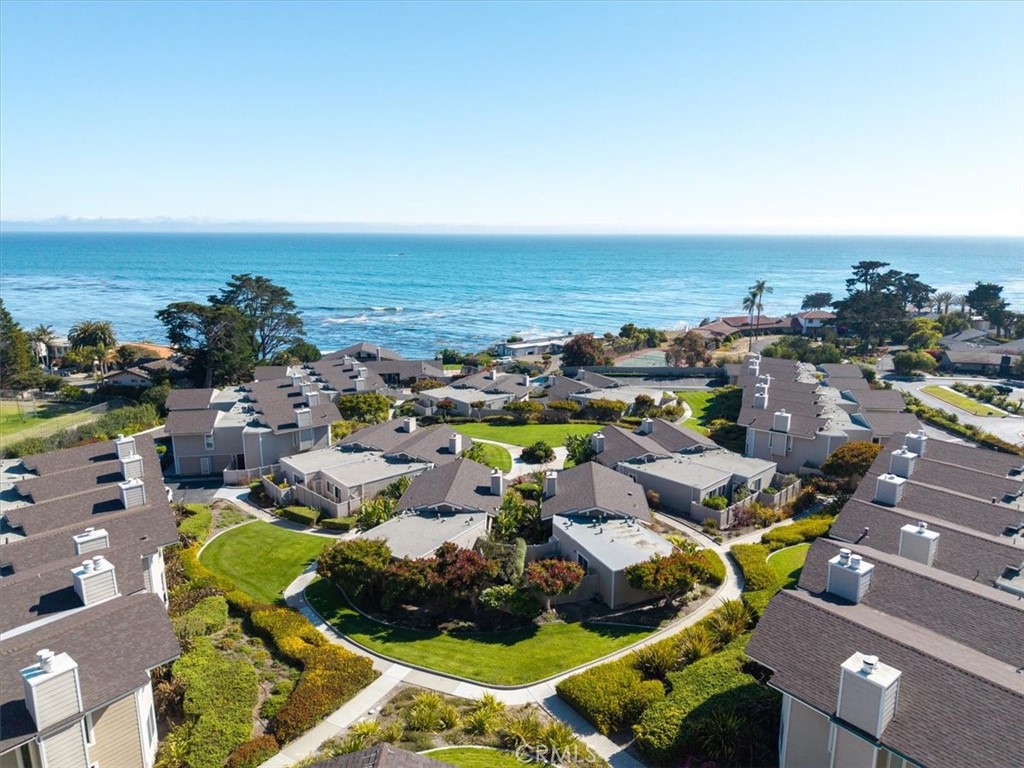 Coastal Grandeur in Shell Beach – A Rare Ocean View Retreat. From the moment you step inside this exquisite Shell Beach condominium, the horizon unfolds before you—rolling waves, shimmering whitewater, and endless sky. This is more than a home; it’s a front-row seat to California’s most captivating coastline. Positioned on the coveted second floor for elevated panoramic views yet designed for the ease of single-level living, this two-bedroom, two-bath residence embodies refined coastal elegance. The open-concept layout is thoughtfully crafted to draw the eye to the ocean from nearly every room, blending natural beauty with high-end finishes. The kitchen features a sprawling granite island and breakfast bar, framed by limestone backsplashes and custom cabinetry. Brazilian hardwood floors add warmth, while crown molding and wainscoting provide classic sophistication. Both bathrooms have been transformed into spa-like retreats, showcasing travertine showers, limestone counters, and premium fixtures. Additional details—such as the gas-insert fireplace, designer lighting, and abundant storage—speak to both comfort and functionality. Step onto your private balcony to witness whales breaching, dolphins playing, and sunsets painting the Pacific in gold and crimson. By night, the same vantage point offers stargazing that rivals any planetarium, and on special occasions, you’ll have the best seat in the house for fireworks over the Pismo Pier. This exclusive community offers a lifestyle most can only dream of. The newly renovated oceanfront clubhouse is a social and scenic centerpiece, complete with a hot-tub and heated pool that seems to spill into the sea, billiards and table tennis rooms, a card lounge, a commercial-grade kitchen, and expansive decks perfect for entertaining. Your guests will appreciate plentiful parking, and you’ll enjoy the convenience of a private garage space, an exterior parking spot, and guest parking along the quiet private road. This peaceful enclave lies at the quiet end of Pismo Beach, yet it’s only a short stroll to Shell Beach’s boutique shops, acclaimed restaurants, charming parks, and sandy beaches—whether by scenic road or the shoreline path. Here, every detail reflects a life well-lived: the balance of luxury and comfort, the connection to nature, and the sense of being exactly where you’re meant to be. This is coastal living without compromise—your sanctuary above the sea.