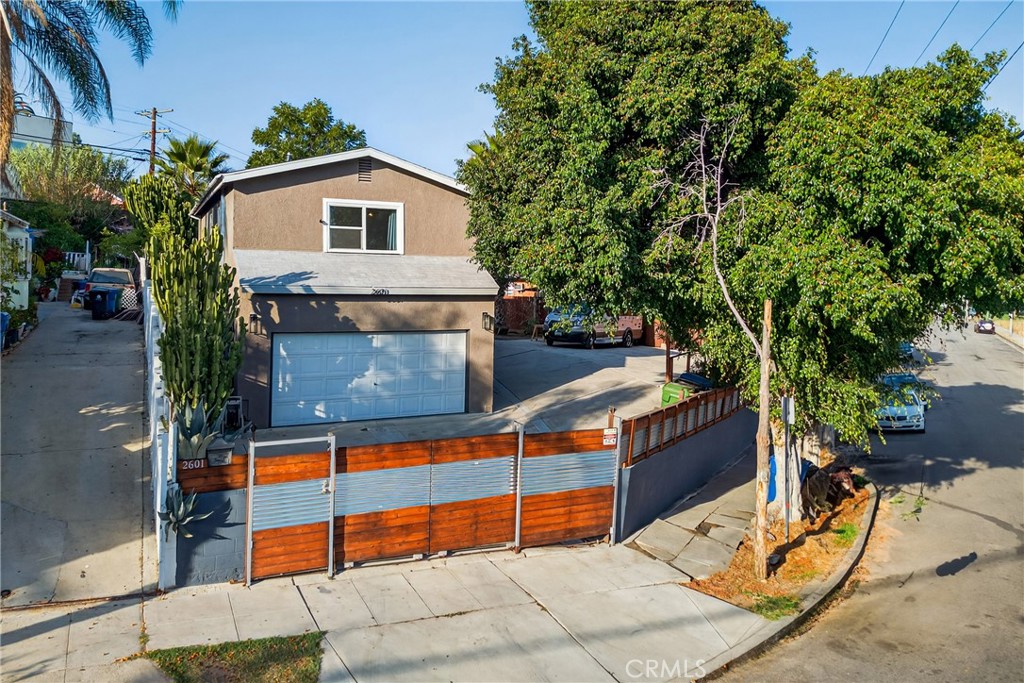 Discover a rare opportunity to own a versatile private compound in the heart of Los Angeles—perfect for multigenerational living, student housing, or professionals working at the nearby USC Health Sciences Campus.
This charming 3-bedroom, 2-bathroom home spans approximately 1,200 sq. ft. and is set on a generous 6,814 sq. ft. gated lot. The expansive yard offers endless possibilities. Surrounded by lush landscaping and mature fruit trees, the property provides both privacy and a serene retreat from city life.
In addition to the main residence, the property features a bonus unpermitted garage conversion (approx. 330 sq. ft.) with kitchen and ¾ bath, ideal for use as a guest suite or in-law quarters. A detached workshop/office provides flexible space for creative pursuits, remote work, or additional storage.
The expansive driveway accommodates multiple cars as well as an RV or camper, making it perfect for households with extra vehicles or travel needs. Eligible for the USC Neighborhood Homeownership Program, this home is an excellent opportunity for USC employees to live just minutes from campus while building equity in a thriving community.
The location also offers easy access to Downtown LA, Pasadena, Alhambra, Cal State LA, public transportation, shopping, and dining, with nearby cultural and recreational destinations like El Sereno, Highland Park, Lincoln Park, and the Arts District adding to its appeal.
Whether you’re seeking a multi-use property for extended family, an investment for student rentals, or a private retreat with abundant outdoor space, 2601 Chelsea St is a property that truly has it all.
