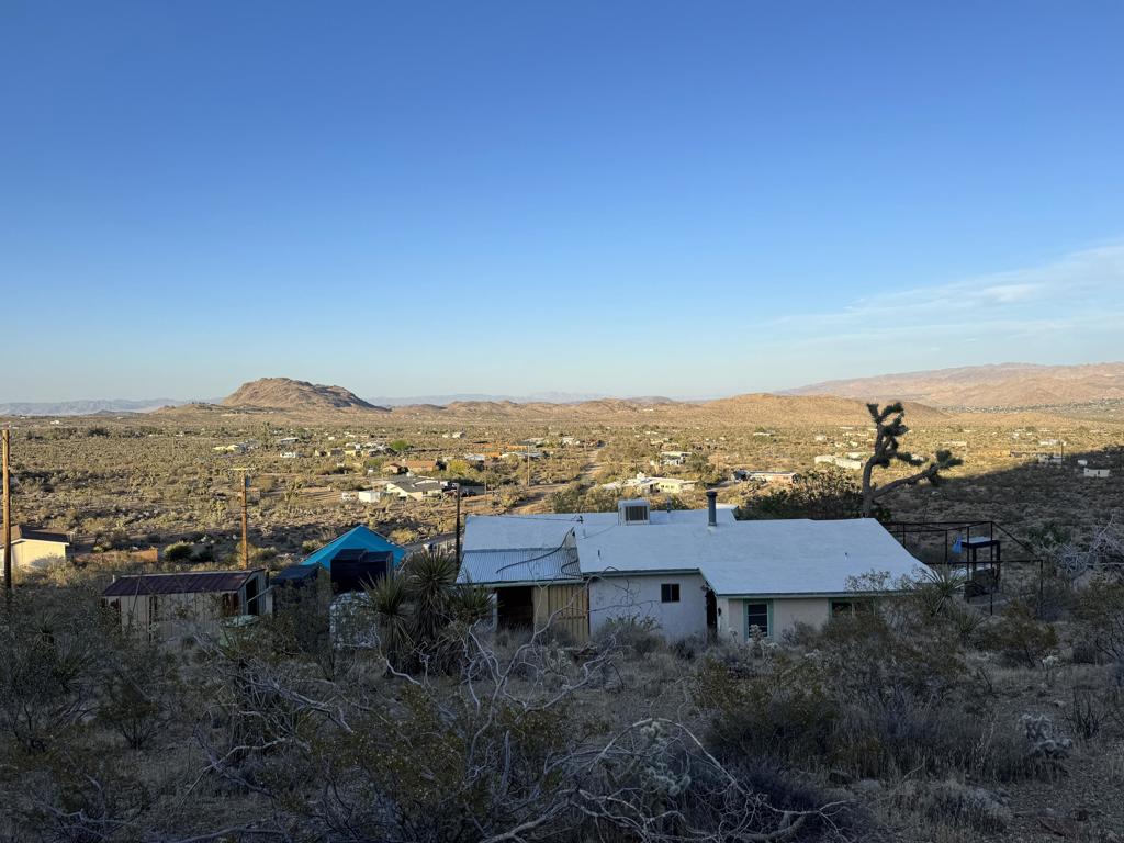 Vintage hill side retreat with Panoramic Desert views on 5 acres. Is connected to city water and electric. Escape to timeless serenity in this rare 1950's home perched high up on the hillside. Step inside and be transported back to a simpler era- Original character throughout with solid construction. Whether you are looking to preserve its vintage soul or infuse it with modern design, this canvas awaits you. Should qualify FHA submit offers now
