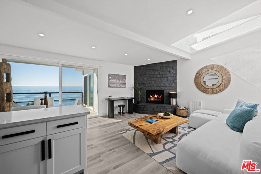 Beachfront Bliss on Malibu Road. Welcome to your dream coastal escape on one of Malibu's most sought-after streets! This beautifully remodeled 2bed/2bath beachfront unit offers an effortless blend of modern comfort and laid-back coastal chic, nestled in an intimate four-unit building right on the sand. Step into a bright, airy living space where sliding glass doors frame sweeping ocean views and natural light pours in from every angle. The updated contemporary kitchen features new appliances, stylish countertops, and a seamless flow into the open-concept living and dining area complete with a cozy fireplace that sets the mood for sunset evenings. Slide open the glass doors to your private beachfront deck, an ideal setting for morning coffee, al fresco dinners, or simply soaking in the sound of the waves. Keep an eye out for dolphins playing in the surf - this is Malibu living at its finest. Both bedrooms have updated bathrooms and serene coastal vibes. The unit includes a one-car garage plus an additional tandem parking space, along with direct access to the sand just steps from your door. Located minutes from Malibu's best dining, shopping, and entertainment, this rare gem offers a blend of convenience and seclusion. Live where every day feels like a vacation-relaxing, revitalizing, and surrounded by the beauty of the Pacific.