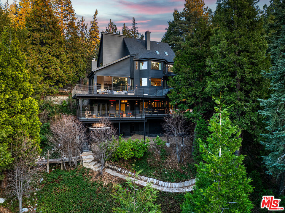 Nestled in the prestigious Arrowhead Woods Community within the exclusive Cedar Ridge Estates, this stunning 5-bedroom, 5-bath Danish Modern Chalet redefines mountain luxury. With expansive, breathtaking lake views, this 4,448 sq. ft. masterpiece sits on 5.43 acres, offering unparalleled privacy and tranquility.Lake Rights included, giving you access to dock ownership and all the amenities Lake Arrowhead has to offer! Recently transformed through an extensive renovation, this home has been updated from a classic lodge to a modern retreat. Highlights include a brand-new chef's kitchen, sleek new flooring, spa-like bathrooms, and spacious new decks designed to showcase the panoramic views.Designed to feel like your private mountain spa retreat, the property boasts your own hiking trails, a cedar hot tub, large sauna, cold plunge, firepits, fireplaces, steam shower, and a heated driveway for year-round convenience. Relax with cutting-edge technology, including a fully automated Control 4 home system, and take comfort in the Frontline Sprinkler Foam Retardant System for fire safety and peace of mind.All this, just 1 hour and 30 minutes from Los Angeles. Don't miss this one-of-a-kind retreatschedule your private tour today and experience the pinnacle of Lake Arrowhead living!