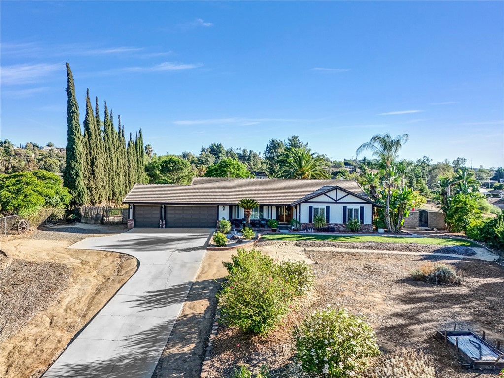 Lovely Woodcrest Area Single Story Ranch Style Pool Home With Great View and Zoned For Horses!
4 Bedrooms 2 Baths PLUS Approximate 900 Sq Foot Great Room with Floor To Ceiling Fireplace With Windows On Both Sides Overlooking Rear Yard, Open Beam Ceiling, Built-In 14' Oak Bar, Distinctive Ceiling Fans. This Is Perfect Room For Entertaining! Very Open Kitchen With Large Eating Area. Inside Laundry Room and Walk-In Pantry; Plantation Shutters Throughout The Home; New Flooring In Hallway, Living Room and Entry. Pool and Spa Have New Plaster and Tile. Fresh New Paint on Exterior Trim, Eaves and Garage Doors; Rear Yard Is An Entertainers Delight: Covered Patio For Relaxing and Watching TV, 14' Island Palapa Overlooks Pool and Spa. More Than 300 Mature Trees Including Over 4 Dozen Fruit Trees and 7 Types Of Of Citrus Trees. Wild Flowers Put On A Show On The South Facing Slopes Of Rear Yard! Cost Effective Drip System Accompany All Plants On The Property. Dozens Of Low Voltage And Solar Landscape Lighting Dot The Property Both Front, Rear and Corral Below.