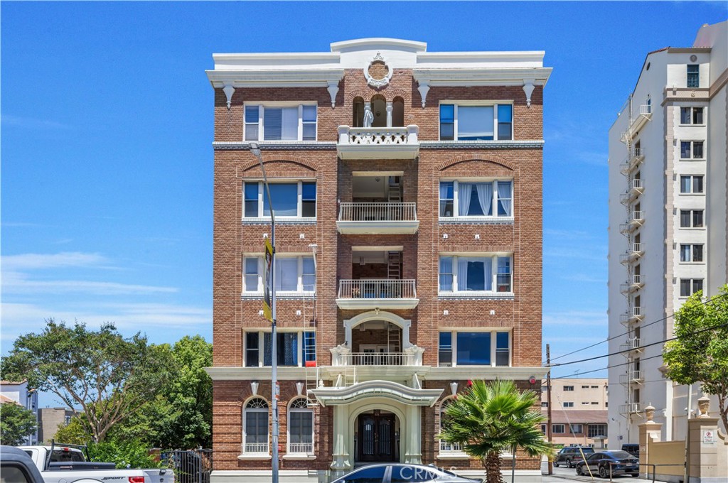 Step back in time to the Roaring 20s and the charming Beaux-Arts design of the iconic Californian built by Joseph Roberts in 1923. With a stunning top-floor solarium and grand lobby, it has all the feels of The Great Gatsby and all the conveniences of modern living. Recently updated electrical grid, working elevator, and smartphone technology washers and dryers in the laundry room. You are in the thick of it in Downtown Long Beach, with all its vibrant nightlife and fast-paced walkability. Just steps to the theatre, the aquarium, the metro, The Pike, Pine Ave and the beach! Speaking of steps, the unit is only one floor up, so you don't even need the elevator. The extra-wide staircase goes from the front of the building directly to your TWO FRONT DOORS! That's right, you have 2 entrances, so you could easily have a roommate you never see! The first door leads to a cozy living room with sleek black walls and white floors, extra high ceiling and wall-to-wall windows letting in tons of daylight, and overlooking the majestic First Congregational Church with its striking Italian Romanesque Revival architecture! This is your view! Double doors were installed for privacy, or leave them open to the small dining room and renovated kitchen, complete with stainless steel appliances, including a BRAND NEW STOVE! Tastefully chosen finishes give an elevated feel, with a window over the sink and plenty of counter and cabinet space. Down the hall, you'll find the beautiful bathroom with classic penny tiles and exposed brick wall above the updated shower and freshly painted walls. Extra clean and fresh! Finally, the hall opens to a large closet space and then the even larger bedroom, with its own windows and AC unit that stays! This corner, Southwest-facing unit provides the most natural light, and extra square footage you won't find in other units. Icing on the cake, the seller is including 6 months of FREE PARKING! The safest and most desirable month-to-month lot is just a few blocks walk from the building and is included with the sale. ALL FURNITURE INCLUDED! It's all yours, even the TV! Seller has already moved out and thought it would be convenient for an investor looking to rent it out. Or it can be delivered empty if that's preferred. Well-run HOA includes gas, water and trash! Literally all you have to do is come enjoy and live your best life with all downtown Long Beach has to offer!