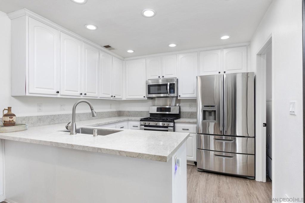 Tucked away in the peaceful Concord Square community of Mira Mesa, this top-floor end unit offers comfort, style, and privacy. Enjoy a spacious layout with a large balcony overlooking a serene, tree-lined greenbelt—perfect for relaxing or entertaining. Inside, you'll find newer LVP flooring and carpet, beautifully remodeled bathrooms, and a bright kitchen featuring crisp white cabinetry, stone countertops, a gas stove, and a refrigerator that stays. The designated laundry room includes a washer and dryer for your convenience. Additional upgrades include window shutters, recessed lighting, and recent exterior improvements, with the roof replaced and building freshly painted within the last year. Community amenities include a pool and spa, all just minutes from shopping, dining, parks, highly rated schools, and convenient access to Interstate 15.