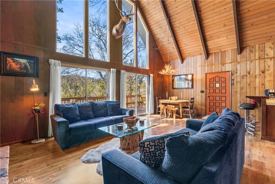 Don't Miss this Mountain Chalet with Lake Rights! Discover the perfect blend of rustic elegance and modern mountain living in this beautifully maintained A-frame style chalet, complete with coveted lake rights. Tucked along a tranquil, tree-lined street, this refined retreat offers nearly a quarter-acre of gently sloping, usable land—an inviting setting for year-round outdoor enjoyment. A level, covered entry welcomes you into a dramatic great room showcasing soaring open-beam ceilings, rich hardwood floors, and a striking wall of glass that frames peaceful forest views and floods the space with natural light. Centered around a classic stone, wood-burning fireplace, the open-concept living area flows seamlessly into an inviting dining space and a well-appointed kitchen featuring crisp white tile countertops, a breakfast bar, and generous cabinetry. Step outside onto the expansive deck—an entertainer’s dream—perfect for al fresco dining, lounging under the stars, or simply breathing in the cool mountain air. A custom Twister Slide and generous deck space add a playful, one-of-a-kind touch to this sophisticated mountain haven. The main level offers a comfortable bedroom and full bath, while the upper level features two spacious guest rooms and a second full bath. Thoughtful updates include newer carpet upstairs paired with original wood paneling that enhances the home’s authentic cabin warmth and sophistication. Designed for comfort and convenience, the property includes parking for up to four vehicles and sits on a main plowed road for effortless year-round access. Just minutes from the lake and The Village, this residence may be available fully furnished—creating a truly turnkey opportunity. Whether you envision it as a full-time residence, a serene vacation escape, or a high-end investment property, this exceptional mountain chalet offers timeless design, natural beauty, and effortless mountain lifestyle. Schedule your private showing and experience mountain luxury today!