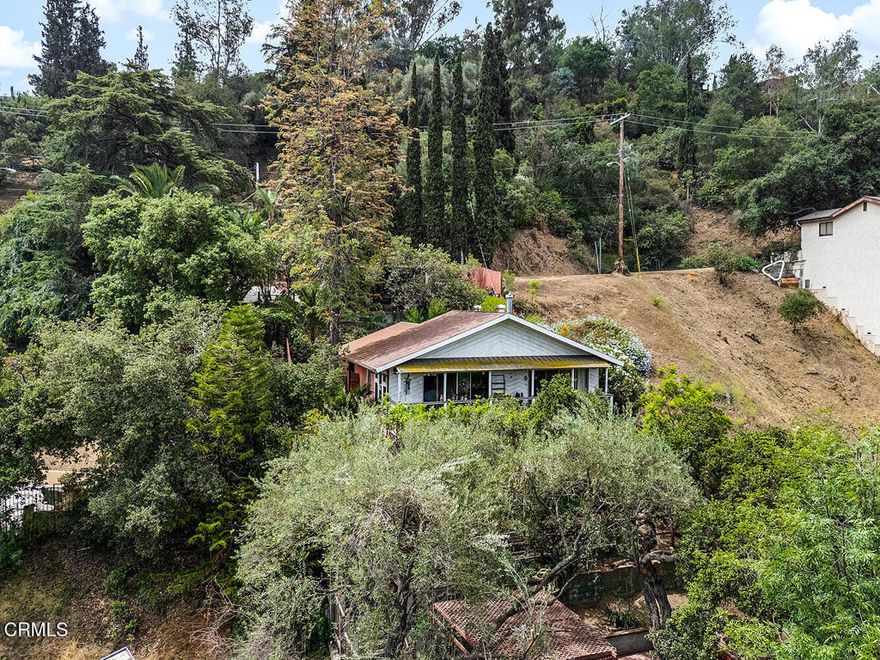 Tucked behind a fence on a peaceful hillside, Casa Escalon feels like a secret garden in the city. With treetop views stretching to the mountains and the iconic Eagle Rock, this 1,615 sq. ft. home on a generous 7,944 sq. ft. lot invites you to create your own private sanctuary.A series of terraces and decks wind through the lush, multi-level yard--each space offering a new perspective and purpose, whether it's morning coffee under the oaks or evenings spent watching the light shift across the hills. Inside, the living room opens to a wide deck that runs the width of the home, perfect for indoor-outdoor living. Spanish-style beams and a graceful archway add charm and character, leading into the dining room and kitchen.The main level also features a bedroom with ensuite full bath, while the lower level offers two rooms with closets that can serve as tandem bedrooms, a den and guest space, or a creative studio setup. A second full bathroom and laundry room with extra storage are located downstairs as well, along with a sliding door that opens to the backyard.There is gated off-street parking for at least two cars, with a carport and driveway space, along with additional storage space in a shed.From the oak tree-shaded deck to the sunlit terraces below, the outdoor space is layered with possibility. Garden, play, entertain, or just retreat - Casa Escalon offers the freedom to dream.