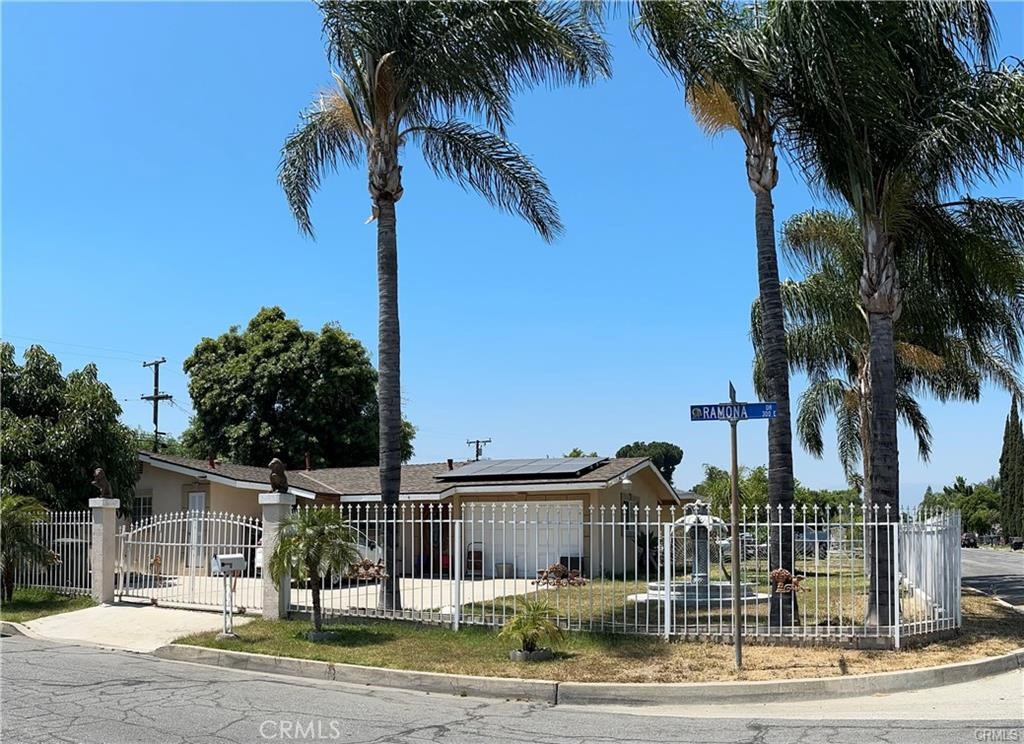 Beautiful home located in the City of Rialto. bedrooms and 1 bathroom, with a kitchen all tile flooring and breakfast bar area. The formal dining room into the spacious living room, where a warm fireplace. Dual pane French doors lead to a private backyard, highlighted by checkered brick flooring and a concrete storage shed. Enjoy outdoor living with a covered patio perfect for entertaining. The home is in great condition, and the garage has been converted into an extra room with a large closet and its own entrance. Situated on a gated corner lot, this property offers privacy and tranquility. The meticulously maintained front yard showcases beautiful palm and fruit trees, along with a picturesque water fountain.