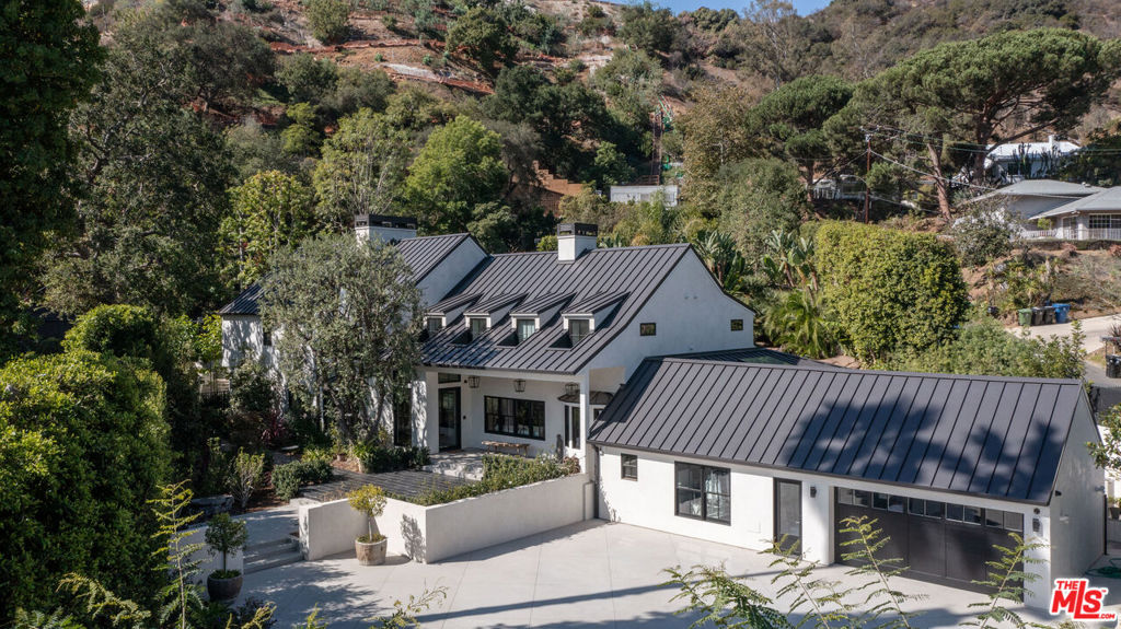 This exquisite two-story estate boasts an elegant main house, spacious guest house, backyard built for entertaining, stunning resort-style pool, lighted tennis court, separate air-conditioned gym, storage building, and beautiful landscaping, all creating a wonderful, private haven. The expansive 0.97 acre lot presents a secluded, cul-de-sac setting for the property which has been completely remodeled and updated. The 4,981 square foot main residence features three bedrooms upstairs, four and a half bathrooms, a finished basement, and an attached 425 square foot, 2-car garage. The splendid two-story guest house provides an additional 1,194 square feet with one bedroom and two bathrooms. There are many fine details and custom designer touches throughout, including whole-house Tensui water purifier system, wine room, backup generator, quartz and porcelain countertops, steam shower, high end euro-style Italian cabinetry, brushed euro oak floors, 32-camera alarm system, outdoor barbecue and pizza oven, impressive pool-side rock feature, solar panels on guest house, sprinklers and drip system, all new plumbing and electrical, kitchen skylight, electric blinds, contemporary gas fireplaces, sun-filled rooms, and other amazing features too numerous to mention. There is ample parking for at least 12 vehicles. Private access is available via both primary and service gates. The entire property is tastefully buffered by well-situated trees and landscaping.