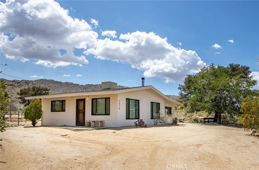 Rural Feel Country Living: Convenient to downtown, hiking, National Park and paved road! Fully-Furnished, Turnkey (minus sentimental items belonging to family) – ready to move in. Great primary residence or parttime getaway supplemented by STR. Fully fenced property, bring you children, pets and horses! Ride into the hills from the back gate at sunset on a full moon night, with a warm, light, easterly breeze and coyotes howling in the distance. Or hang on the back porch sipping an evening beverage, letting the day slip into night & the following morning a cup of joe on the hammock at dawn. Open well-lit interior with large windows and tall, vaulted ceilings finished with tongue and groove natural wood provide an organic ambiance. Solid wood front door accents the rustic, along with the wood door casings entering the bedrooms. Classic kitchen cabinetry with granite counters brings a clean, modern touch – as do the tile flooring and custom travertine tiled shower. Spacious living room for socializing. Freestanding wood stove for cold nights. Dining area and nicely designed kitchen create an inviting warmth, contrasting the wilderness just outside the front door. Hidden by a small stand of trees and brush between the house and the roadway, the exterior exudes privacy with nearby mountain views. Step across the yard into the detached garage, finished as a second living room/theater/late night hang spot, with wine cooler, ductless mini-split AC/Heating, dart board, and even a garage door to fling open at midnight to join the coyotes howling at the moon. Regardless of the many homes for sale, none match the esteemed wilderness/near town aesthetic, remote/rural feel of the one-and-only – glorious – Sunset House!