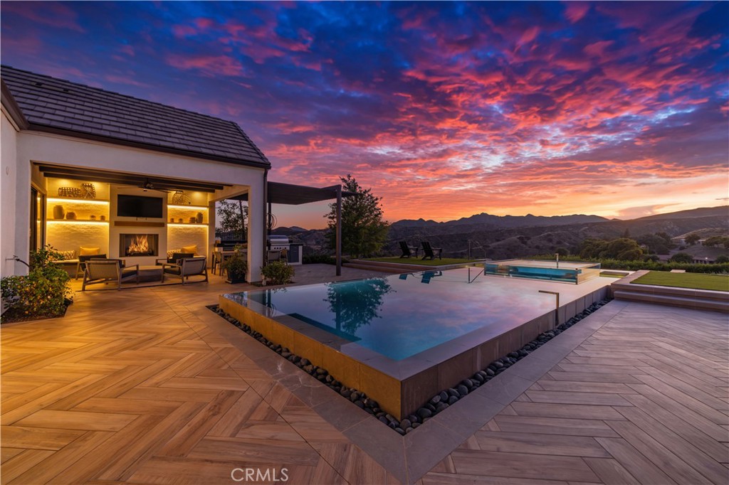 Welcome to 12401 Ridge Line, Luxury Single Story Home located in the prestigious and gated community of Porter Ranch! This former Toll Brothers model home offers the pinnacle of luxury living, making it a true standout in the neighborhood. Enjoy one of the best and exclusive sunset views from the comfort of your own backyard, where you'll find a sparkling pool & spa, mountain views, BBQ area, and meticulously designed landscaping that exudes elegance. The sale of this home includes all the furniture, adding an extra layer of convenience and value! Step inside to discover the chef's kitchen featuring stainless steel appliances and a spacious walk-in pantry. Every corner of this home showcases upgraded finishes and impeccable detail, ensuring an unforgettable experience for both residents and guests. With ample living areas, this home offers functional office spaces, stunning hard flooring, and aesthetically pleasing bathrooms throughout. The master bath is a true sanctuary, boasting a soaking tub, an exquisitely designed and well lit walk-in closet, and a spacious glass standing shower. Additionally, the outdoor area of the master suite features a relaxing outdoor soaking tub in a privately closed area, adding a touch of tranquility to enjoy nature. Indulge in a lifestyle of opulence with scenic walking trails, breathtaking views, and an abundance of space. The backyard is highlighted by a captivating fireplace, epitomizing the quintessential California luxury lifestyle that dreams are made of. Take the first step towards your dream lifestyle today!