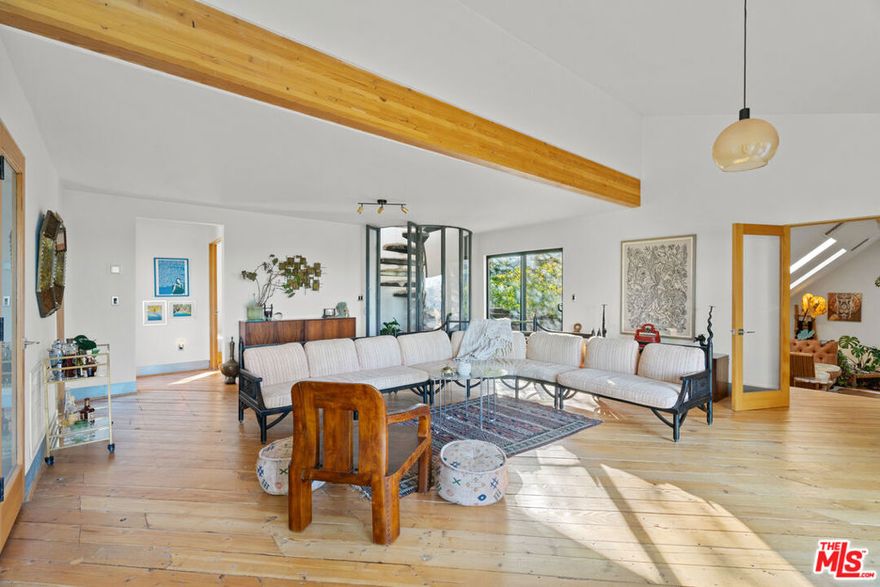 A tranquil retreat perched atop Fernwood in Topanga Canyon. This three-bedroom home offers ample living space with a large living room and a cozy family den. Two bedrooms on the lower level open to a light-filled garden and share a full bathroom. A circular staircase leads to the primary suite with built-in shelves and an ensuite bathroom featuring a vanity station and shower room. The bathtub is positioned beside a Juliet balcony with sweeping canyon views. The home enjoys views of Topanga Canyon and the surrounding mountains from both sides. Lush landscaping surrounds the property, providing privacy and immersion in nature. A spacious concrete patio extends the living space outdoors with a dining area, Green Egg grill, and pizza ovenideal for entertaining. The attached garage includes a gym and infrared sauna for your personal wellness moments. This is the perfect Topanga retreat, where peaceful canyon living meets everyday comfort. One-year furnished lease available January 1st.