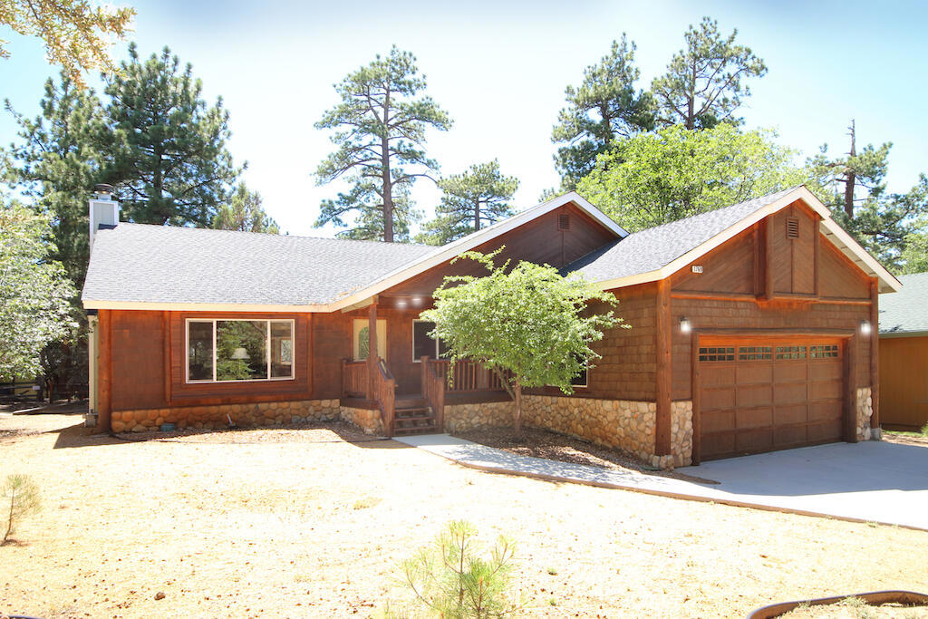 Charming single-level mountain retreat on an expansive lot! Welcome to this beautifully maintained and fully furnished home, nestled on a generous 10,080 sq ft level lot. Designed with comfort and mountain charm in mind, this desirable single-level floor plan features a spacious great room with vaulted tongue-and-groove ceilings and a cozy wood-burning fireplace set against a rustic river rock hearth for relaxing evenings. The kitchen is both functional and inviting with knotty pine cabinetry, granite countertops, a dishwasher, bay window, and newer laminate flooring. The large dining area is ideal for hosting family and friends. Retreat to the primary suite, featuring vaulted ceilings, a spacious walk-in closet, and a luxurious ensuite bath with a Jacuzzi tub and separate tile shower. Two additional generously sized guest bedrooms offer ample space for king beds or bunk setups. Enjoy the outdoors on the large redwood back deck or sip your morning coffee on the covered redwood front porch. Pet owners will love the custom dog run that includes a fence style roof enclosure for animal safety and with a convenient doggie door leading to the garage. Additional highlights include dual-pane windows throughout, indoor laundry closet, interior solid pine six-panel doors, fiberglass exterior entry doors. Attached two-car garage. Central forced heating. Whether you're seeking a full-time residence, vacation home, or rental investment, this turn-key property is ready to enjoy. Furnished per seller's inventory.