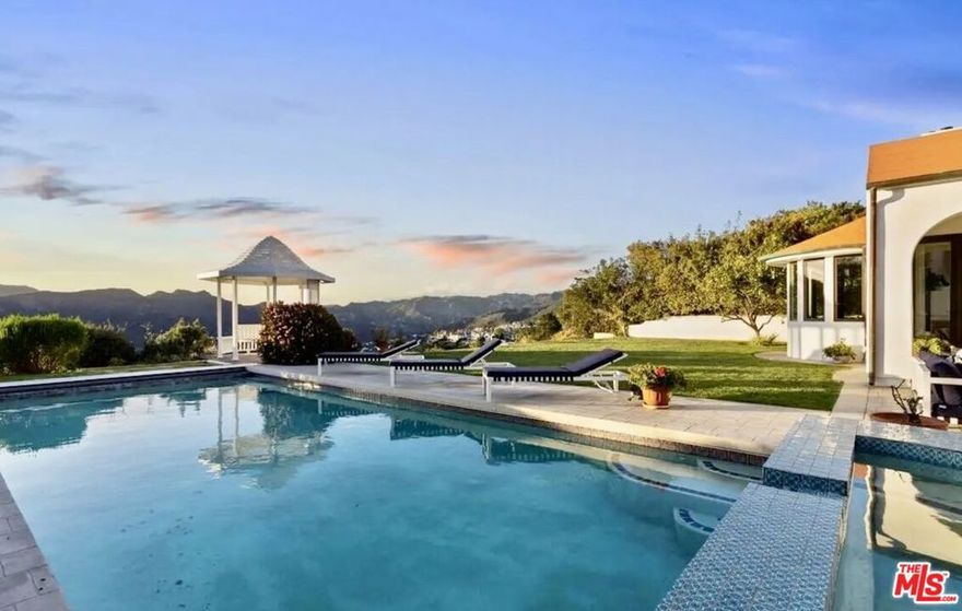 Set on a quiet cul-de-sac in the coveted Upper Marquez Knolls area, 16866 Charmel Lane is a 5-bedroom, 5-bath Spanish-style villa offering 3591 square feet of elegant California design on a 19,338-square-foot lot. Framed by sweeping mountain, canyon, and ocean views, the home blends classic architecture with modern comfort, creating a space that feels both elevated and welcoming.Inside, a recently remodeled designer kitchen with Castle-stone flooring and Miele appliances anchors the main living spaces, flowing seamlessly between the formal living room with fireplace, dining room, and family roomperfect for both relaxation and entertaining. The primary suite serves as a private retreat, featuring a large walk-in closet, spa-like en-suite bath with heated floors, and a balcony overlooking the Pacific. Additional highlights include a library, office, and sauna, along with rich hardwood and tile flooring throughout, offering thoughtful details at every turn.The backyard reflects a timeless indoor-outdoor style, featuring a resort-style pool, spa, and charming gazebo that open to sweeping mountain, canyon, and ocean views. This serene and private setting captures the essence of refined Pacific Palisades living, making it a truly inviting escape.