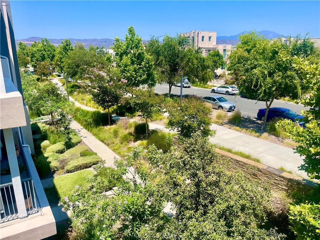View! View! View! Discover this striking, move-in-ready home ideally located on a desirable corner lot in the highly sought-after Parasol Park neighborhood of Irvine's Great Park community. This multi-level residence has been recently refreshed with new paint and upgraded vinyl flooring throughout, offering a modern and inviting feel. This home provides an abundance of living space with four bedrooms, a versatile loft, and a beautiful open-concept layout. On the first floor, you'll find a welcoming living area, a dining space, a convenient powder room, and a well-appointed kitchen. The second floor is home to a luxurious primary suite with an en-suite bathroom and a large walk-in closet, along with two additional spacious bedrooms. The third floor offers a large, versatile loft—perfect for a media room, home office, or playroom. This level also features a private fourth bedroom and a full bathroom, making it an ideal retreat for guests or extended family. Step outside onto the large third-floor deck to enjoy breathtaking, panoramic views of the mountains and green belt—a perfect spot for relaxing or dining al fresco. Beyond your doorstep, you'll be immersed in the vibrant Great Park community. Just across the street is The Pools, a popular community clubhouse with a swimming pool. Residents of this dynamic neighborhood enjoy unparalleled access to a wealth of amenities, including expansive parks, resort-style pools, sports courts, clubhouses, and scenic walking paths. Families will also appreciate being part of the award-winning Irvine Unified School District. This townhouse offers the perfect blend of modern living and an active, amenity-rich lifestyle.