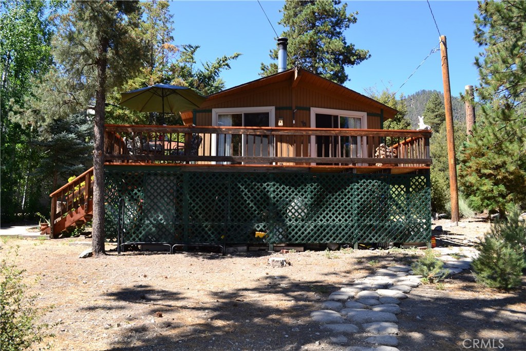 Location, location, location. This is an adorable mountain cabin on a quiet cul-de-sac, with ample off street parking, the National Forest as your backyard and an oversized lot. This two bedroom, one bath home boasts an open floor plan with the living room, dining room and kitchen set for easy entertaining. The living/dining room has sliding glass doors that open out onto the new front deck. The ceilings are wood and beamed with a ceiling fan and new wood looking laminate floors throughout. The kitchen is large with a window over the sink, lots of storage and a breakfast bar. The primary bedroom and guest bedroom both have sliding glass doors that open to the new back deck and the forest just footsteps away. There is also a full bath and laundry area. New ammenities include central air/heat, newer double paned windows, new decks, new water softner system and insulation under the house. This charming mountain getaway wont last.