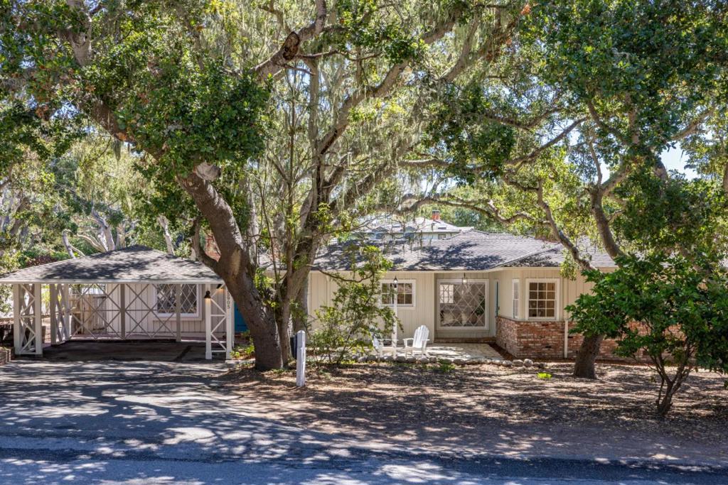 Afternoon sunlight flickers through a twisting melee of California live oak trees to cast speckled shadows all around this endearing single-level home. An uncommonly spacious residence on more than 7000 square feet of land, it displays all the charm of a classic Carmel-by-the-Sea cottage. Attractive Dutch doors open into softly glowing, inviting spaces where hardwood flooring contrasts magically with creamy white walls, gently elevated ceilings, and brick fireplaces. Here is a property that expresses itself distinctively, but in subtle whispers, its warm neutral color palette teasing the eye with hints of pastel and arresting it with mouthwatering impressions through diamond-pane windows of natural surroundings that place you unmistakably in Carmel. Wake up each morning with the deep pleasure of knowing you are only a leisurely stroll or easy drive from the heart of this special community to which people travel from all corners of the world. Spend an afternoon perusing art galleries or playing with your dog on Carmel Beach before heading back to your very own slice of this rarefied dreamscape on the Monterey Peninsula. Plus, the home is only steps away from a trailhead leading into the scenic Mission Trail Nature Preserve. We know it for a fact: life really can be this beautiful.