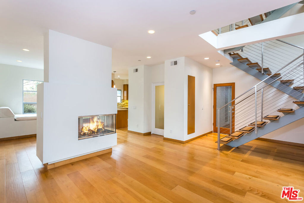 Just steps from the sand and only one block from the vibrant boutiques and cafes of Main Street, this stunning architectural townhome in prime Ocean Park offers the ultimate coastal lifestyle, now available for lease. Spanning three levels, this impeccably maintained residence boasts a private rooftop deck with peek-a-boo ocean views, along with a serene outdoor patio and Zen rock garden. Inside, dramatic 30-foot ceilings and a striking three-story floating staircase set the stage, complemented by rich maple hardwood floors throughout. The open-concept living and dining area features a dual-sided gas fireplace and a built-in daybed, offering a peaceful retreat filled with natural light. The sleek kitchen is outfitted with Caesarstone countertops, glass tile backsplash, stainless steel appliances, and refrigerated filtered water. Upstairs, two spacious bedrooms each feature their own en-suite full baths, with a stackable washer/dryer conveniently located on the second level. Enjoy the ease of direct garage access with two side-by-side parking spots, plus guest parking, all within a secure, well-maintained 5-unit complex. This is a rare opportunity to lease a design-forward home in one of Santa Monica's most coveted beachside neighborhoods.