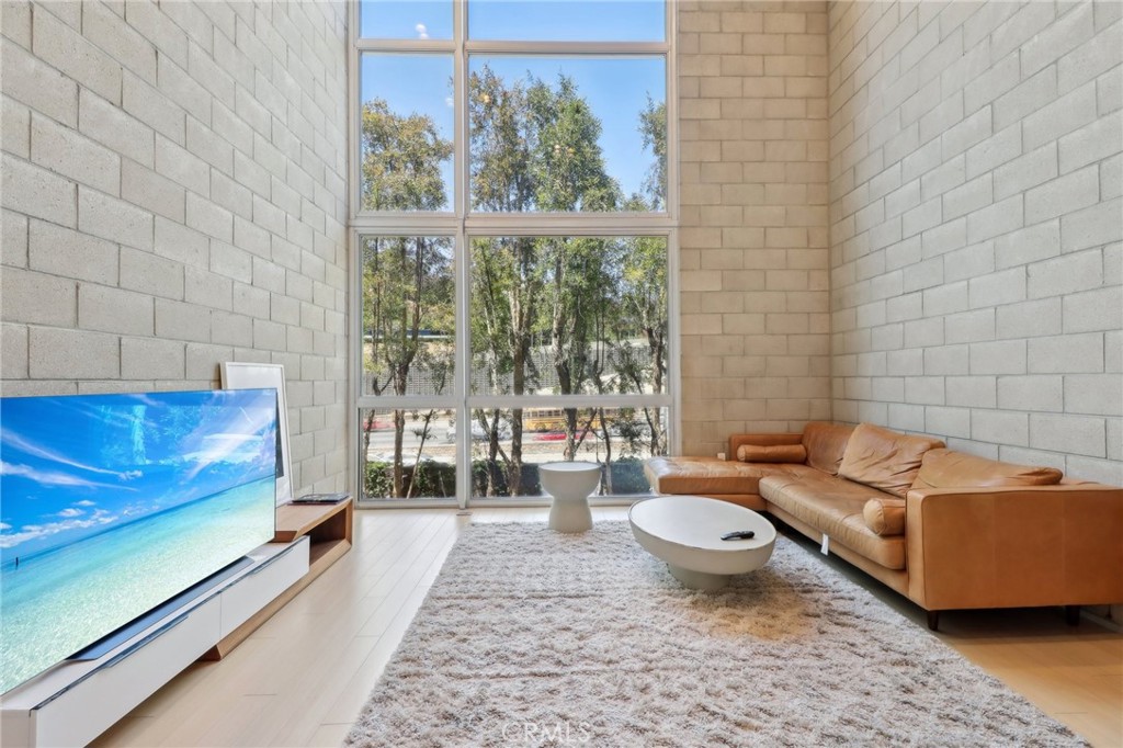 Introducing an exquisite 2-bedroom, 2.5-bath townhouse nestled in the heart of the prestigious Hollywood Hills. This stunning 1,921-square-foot residence, built in 2008, blends modern sophistication with industrial charm, offering a versatile live/work sanctuary. The home boasts soaring ceilings, exposed brick accents, and floor-to-ceiling windows that bathe the interior in natural light, creating an airy and inviting ambiance. Tucked in a tranquil corner of a secure, gated community, this unit ensures privacy while showcasing breathtaking views of Universal Studios from the expansive living room. The open-concept layout features a sleek, updated kitchen, a dedicated dining area, and a private balcony perfect for al fresco dining or quiet relaxation. Custom automatic blinds elevate both style and convenience throughout. The luxurious primary suite is a true retreat, complete with ample closet space, a spa-like en-suite bathroom with a soaking tub and walk-in shower, and access to a second private balcony. Additional highlights include a private 2-car garage, a dedicated laundry room, and resort-style community amenities such as valet guest parking, a dog walk, BBQ area, and chic outdoor lounges ideal for entertaining. Perfectly positioned just moments from Universal Studios and Burbank’s major studios, this live/work-zoned townhouse offers an unparalleled blend of luxury, functionality, and convenience for professionals seeking a vibrant yet serene lifestyle in the Hollywood Hills.