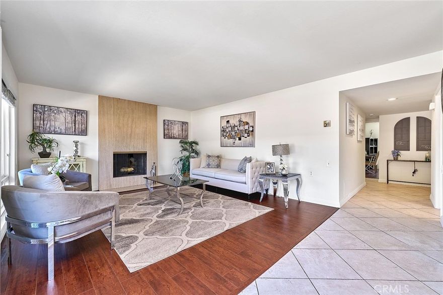 This beautifully maintained 2-bedroom, 2-bath home offers a perfect blend of comfort and style. Step into a bright and inviting space featuring fresh new paint, a spacious entry with large tile flooring, and wood-look flooring throughout the main living areas. The cozy fireplace in the living room creates a warm focal point, while dual-pane windows bring in abundant natural light. Enjoy relaxing or entertaining on the expansive private balcony, perfect for taking in the serene surroundings. The open-concept living and dining area is filled with sunlight, making this home feel airy and cheerful. Located in a tranquil, tree-lined setting with access to resort-style amenities including golf, swimming, fitness centers, and more, this home offers the best of 55+ living. Don't miss your chance to enjoy the Laguna Woods lifestyle!