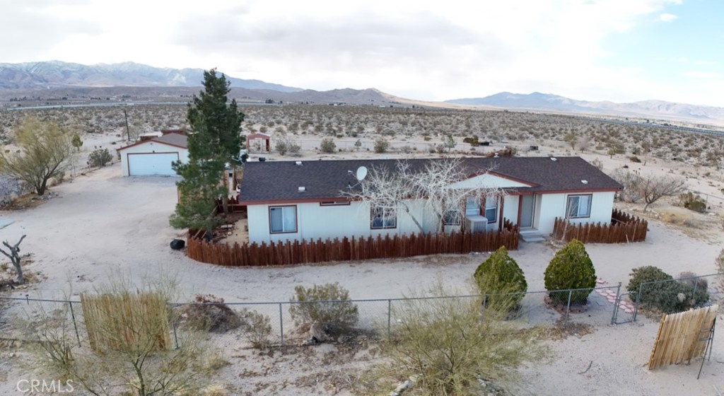 Large Double Wide 3 bedroom, 2 bath home on permanent foundation with easy paved road access this property sits on nearly 5 ACRES of land with stunning views all around fully fenced with 2x fences around the land providing both security and privacy the kitchen features white modern cabinets, pantry, and ample storage high ceilings with a large open layout with a formal dining room, formal living room, laundry room, and split floor plan! tile floors throughout and ceiling fans this home also offers 40 jujube trees, a detached garage, additional sheds, a carport AND MORE! prime location short distance to schools, parks & centrally located to all shopping centers and restaurants within mintues from Big Bear this unique home will not disappoint !!