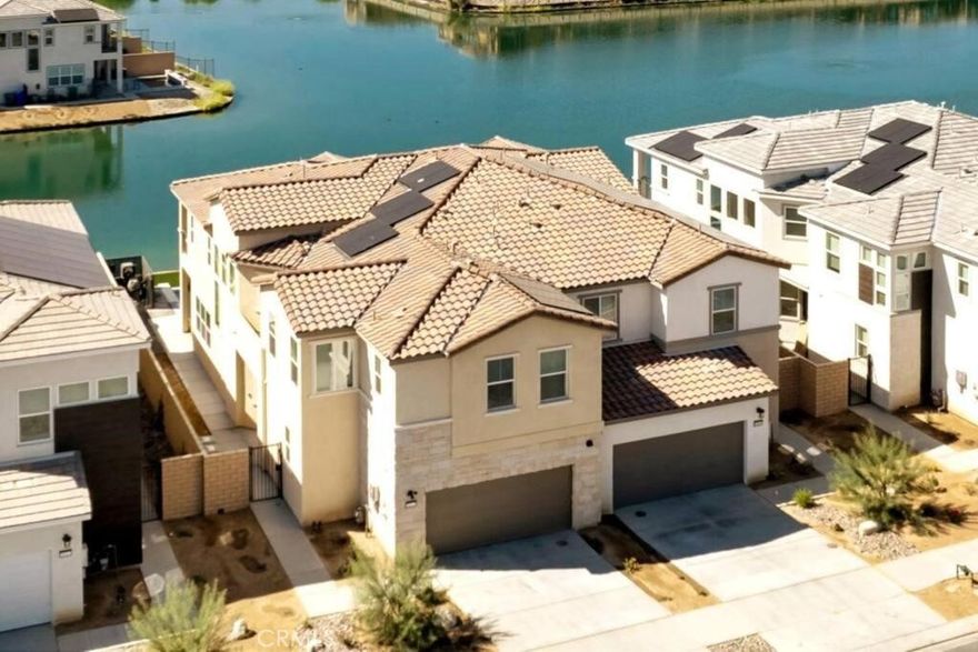 Experience luxury lakefront living in this beautifully updated and fully furnished 2-story Indio home in the sought-after, Terra Lago community. Featuring 4 bedrooms, 4 bathrooms, and an additional upstairs bonus room that can function as a 5th bedroom. This bright, modern residence offers an open-concept layout with upgraded tile flooring, fresh designer paint, and large windows showcasing stunning water views. The updated gourmet kitchen features quartz countertops, stainless-steel appliances, custom cabinetry, and elegant pendant lighting that flows into the spacious dining and living areas. The remodeled primary suite includes a private balcony with panoramic lake and mountain views. Outside, enjoy a resort-style backyard with modern concrete hardscape, artificial turf, updated pool tile, multiple seating areas, and a sparkling pool overlooking the serene lake. Energy-efficient solan panels provide added savings and value. Turnkey, beautifully upgraded, and set on rare waterfront: this home offers the ideal blend of comfort and luxury living. Whether you’re ready to buy your first home or looking for the perfect investment opportunity with this short-term–rental-approved property… you can’t go wrong with this one.