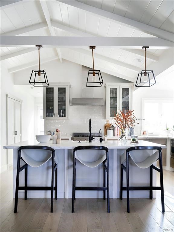 A thoroughly updated, fully furnished quintessential two-bedroom cottage in the heart of North Laguna Beach with ocean views! No expense was spared in the renovation of this approximately 1,200 square foot space, with the resulting interiors a perfect blend of high-end finishes and charming original architectural elements. Just beyond the Dutch door entryway, the open main space includes an airy living room with beamed ceilings and a brick-mantle wood-burning fireplace for chillier times of the year. The adjacent bright kitchen, anchored by a center eat-in island, is luxurious and abounds in high-end elements including Calacatta countertops, a suite of stainless steel Bertazzoni appliances, and bespoke white cabinetry. Well situated just below one of the home’s many windows is a secondary eat-in area with built-in L-shaped bench seating. The primary suite with a vaulted ceiling offers access to the private courtyard via French doors. The outdoor areas of 283 Chiquita Street are as stylish as the property’s interior, with meticulously maintained mature landscaping and a spacious patio perfect for a large table set up. Additional features include a single parking space in a two-car garage, French white oak flooring and wool carpeting, a home security system, newer air conditioning and heating units, custom blinds, lighting, and a laundry room with a sink. Incredible location, with Laguna’s beaches, galleries, boutiques, and restaurants just minutes away.