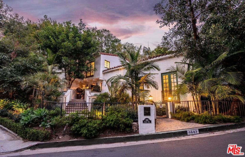 Featured in Architectural Digest and rich with Hollywood history, this reimagined gated and tastefully FURNISHED (unfurnished optional) Spanish villa seamlessly blends modern amenities with timeless old-world charm. Nestled in the hills above the Sunset Strip, the 3-bedroom + Office (4th bedroom), 4-bathroom home is thoughtfully positioned at the heart of the property, offering lush greenery views from every window and French door. The separate 1-bedroom, 1-bathroom guest studio ensures privacy and tranquility for visitors. Set back from the street, the home welcomes you into a formal entryway, leading to an elegant dining room and a living room adorned with beamed vaulted ceilings, a wood-burning fireplace, and an abundance of natural light. The chef's kitchen boasts Caesarstone countertops, a breakfast bar, and a cozy dining area overlooking the backyard, complete with a sparkling pool and spa. Outdoor patios and a covered dining area with heaters create the perfect setting for entertaining. Upstairs, the luxurious owner's suite features Romeo and Juliet balconies, an oversized dressing room, and a spa-inspired bathroom with designer tiles and fixtures. Beautifully designed secondary bedrooms and bathrooms highlight meticulous attention to detail throughout. Additional features include premium fixtures by Waterworks, Lefroy Brooks, and Kallista, Ann Sacks tiles, an outdoor fireplace, surround sound, security cameras, and Nest technology. Parking is a breeze thanks to the 2-car garage and additional off-street parking for 2 cars. This home is an entertainer's dream, offering both sophistication and serenity in a highly coveted location.