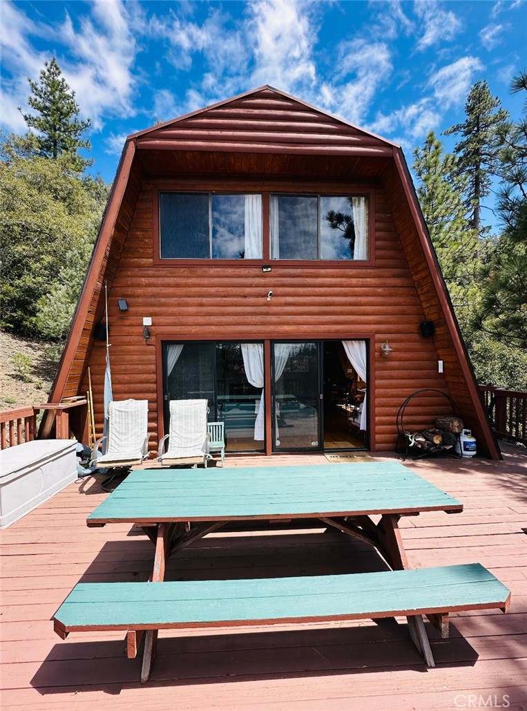 Perched high on a scenic hill, this charming log-sided home blends mountain character with modern functionality. An oversized front deck offers the perfect space for entertaining, while multiple secluded seating areas behind the home provide quiet spots to relax and take in the natural surroundings.
The property includes a spacious two-car garage with an additional workroom and a paved driveway below—ideal for parking, storage, and weekend projects. Inside, the upper level features two generously sized bedrooms and a full bath. On the main floor, you'll find a cozy living room, a dining area perfect for hosting, a well-appointed kitchen, and a convenient three-quarter bath.
This unique mountain retreat offers space, comfort, and style—plus the added bonus of a 1/2 interest in the neighboring parcel.